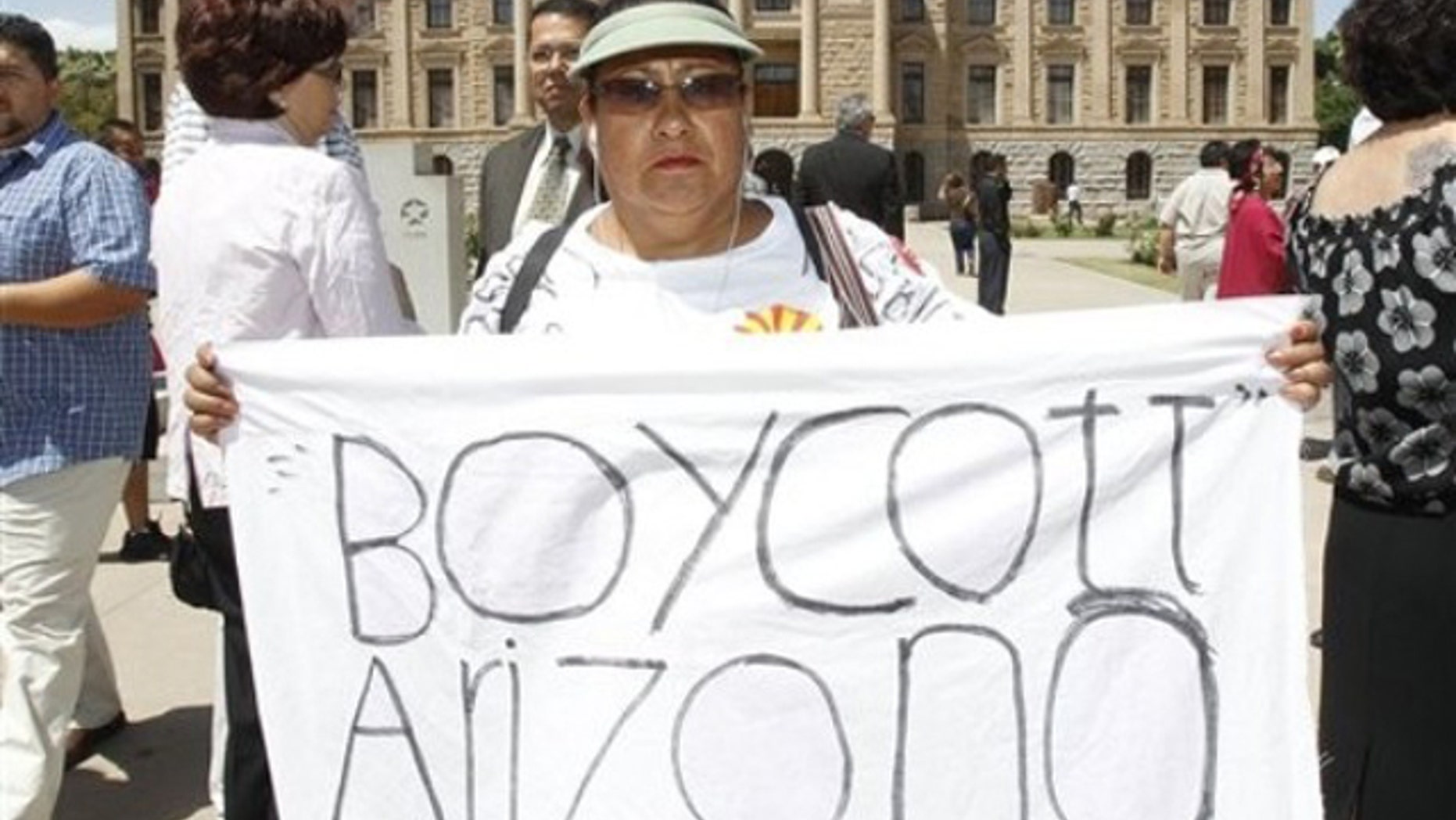 This April 29 file photo shows Josephine Nevarez, of Phoenix, holding a sign in protest of the Arizona immigration law at the Arizona Capitol in Phoenix. (AP Photo)
