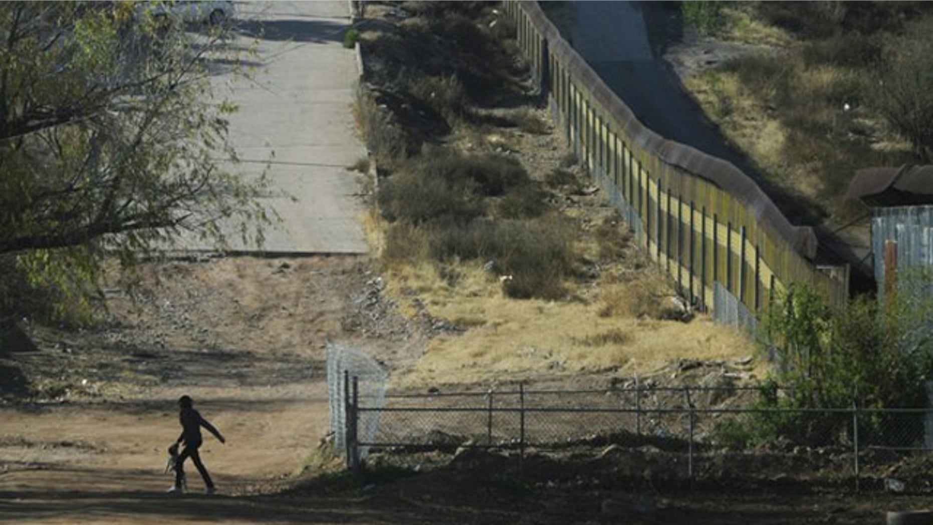 Jan. 6: A woman with a dog walks near the border fence between Mexico and the United States in Nogales.