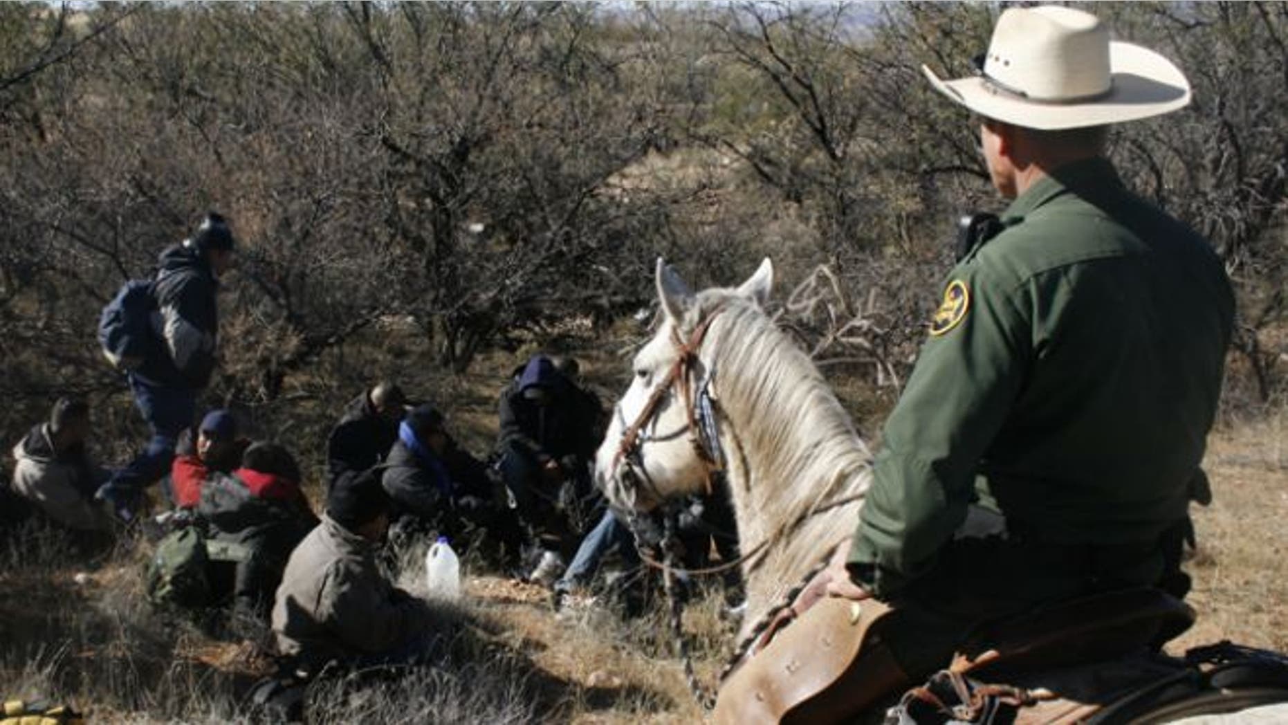 FILE: Jan. 9, 2008: A U.S. Border Patrol agent watches over a group of immigrants arrested after crossing illegally from Mexico through the Altar Valley in Arizona.