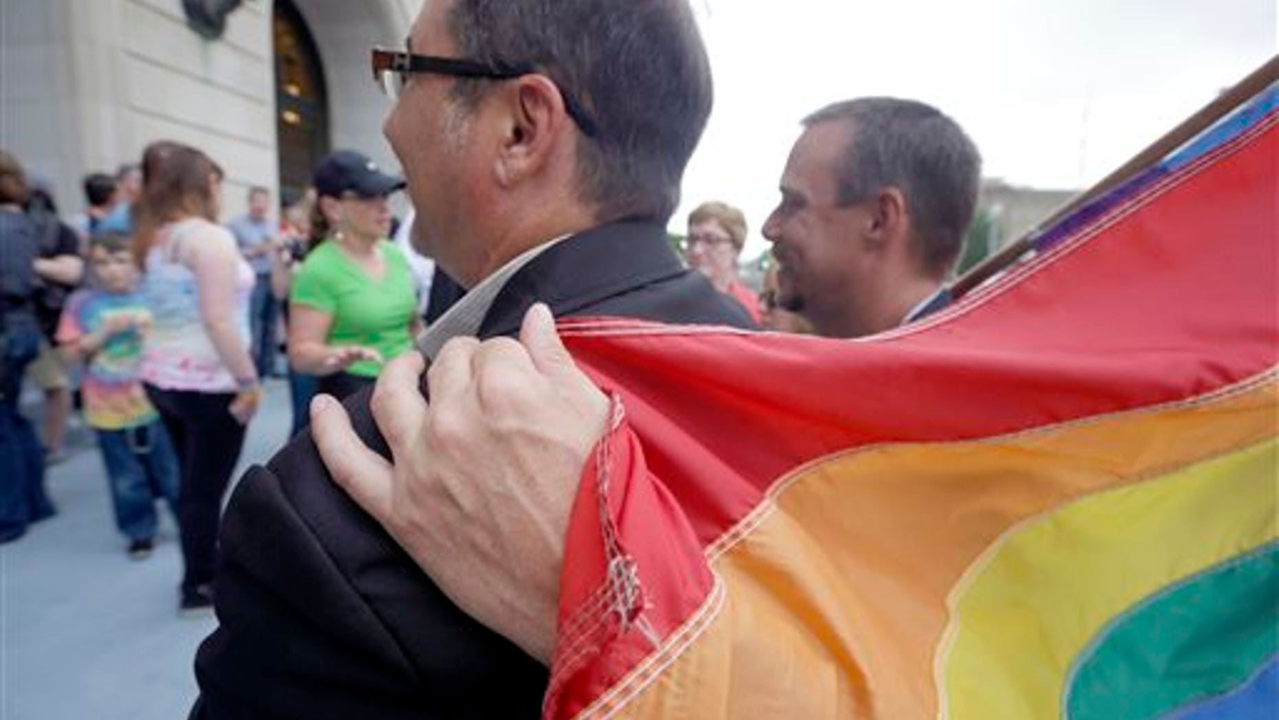 May 12, 2014: Shon DeArmon, right, puts his arm around his partner James Porter while holding a flag outside the Pulaski County Courthouse in Little Rock, Ark.