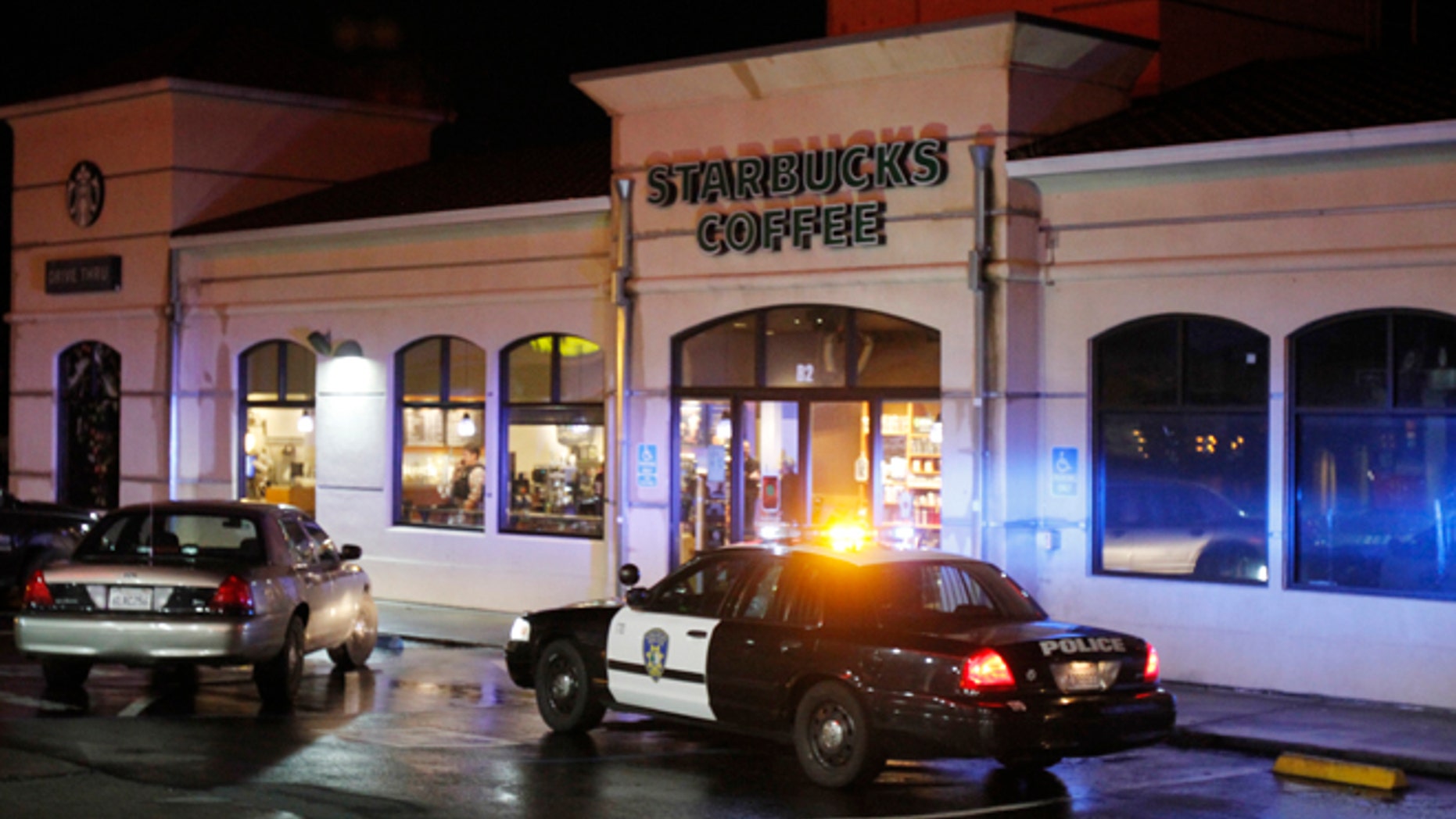 Vallejo Police officers work at the scene of a shooting in Vallejo, Calif., on Sunday, Oct. 16, 2016. Andrew Powell targeted two Northern California police officers who were taking a break at a coffee shop in an ambush that was foiled when his gun malfunctioned, a police chief said Monday.