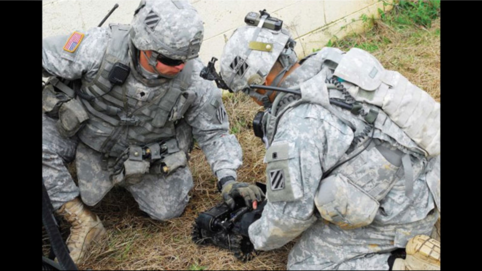 Two Soldiers prepare a robot for a mission as part of an experiment at Fort Benning, Ga.
