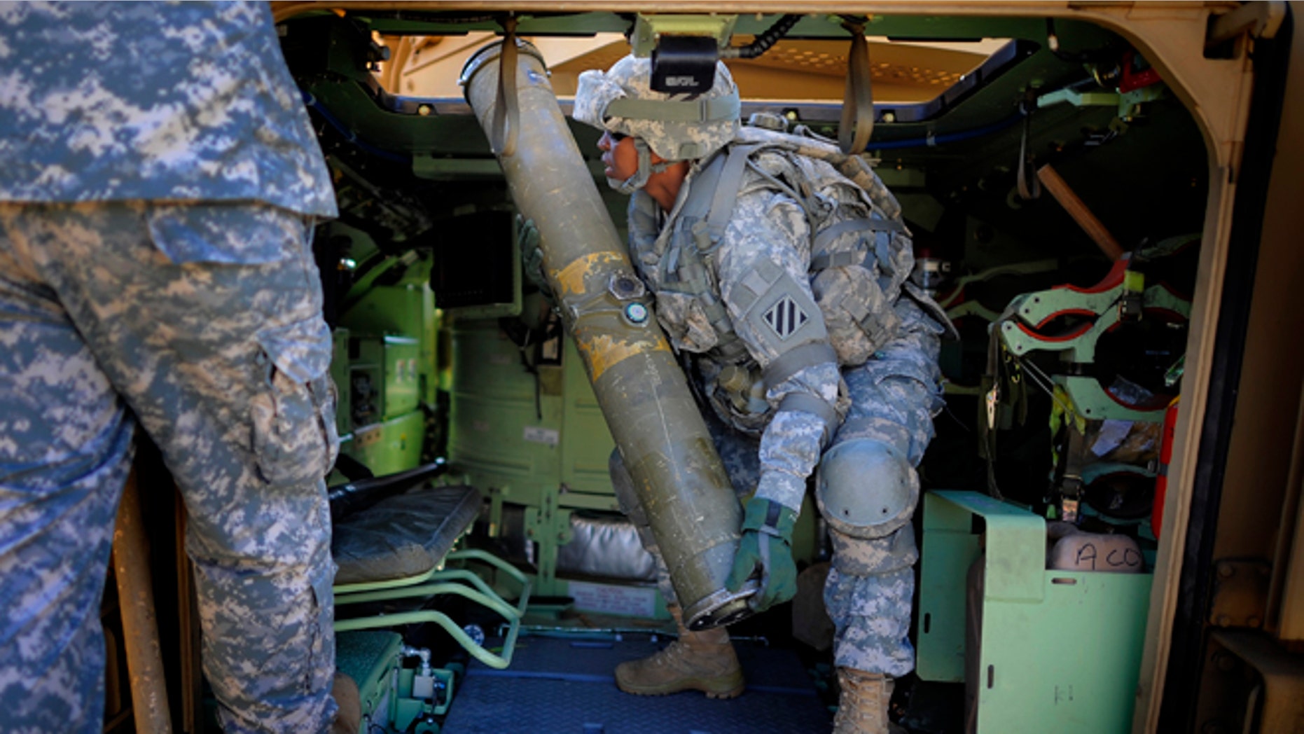 Feb. 25, 2014: U.S. Army Corp. Jacqueline Beachum lifts a 65-pound dummy T.O.W. missile into the launcher of a Bradley Fighting Vehicle during a physical demands study in Ft. Stewart, Ga. The Army is conducting a study that will determine how all soldiers, including women, for the first time, will be deemed fit to join its fighting units from infantry platoons to tank crews.