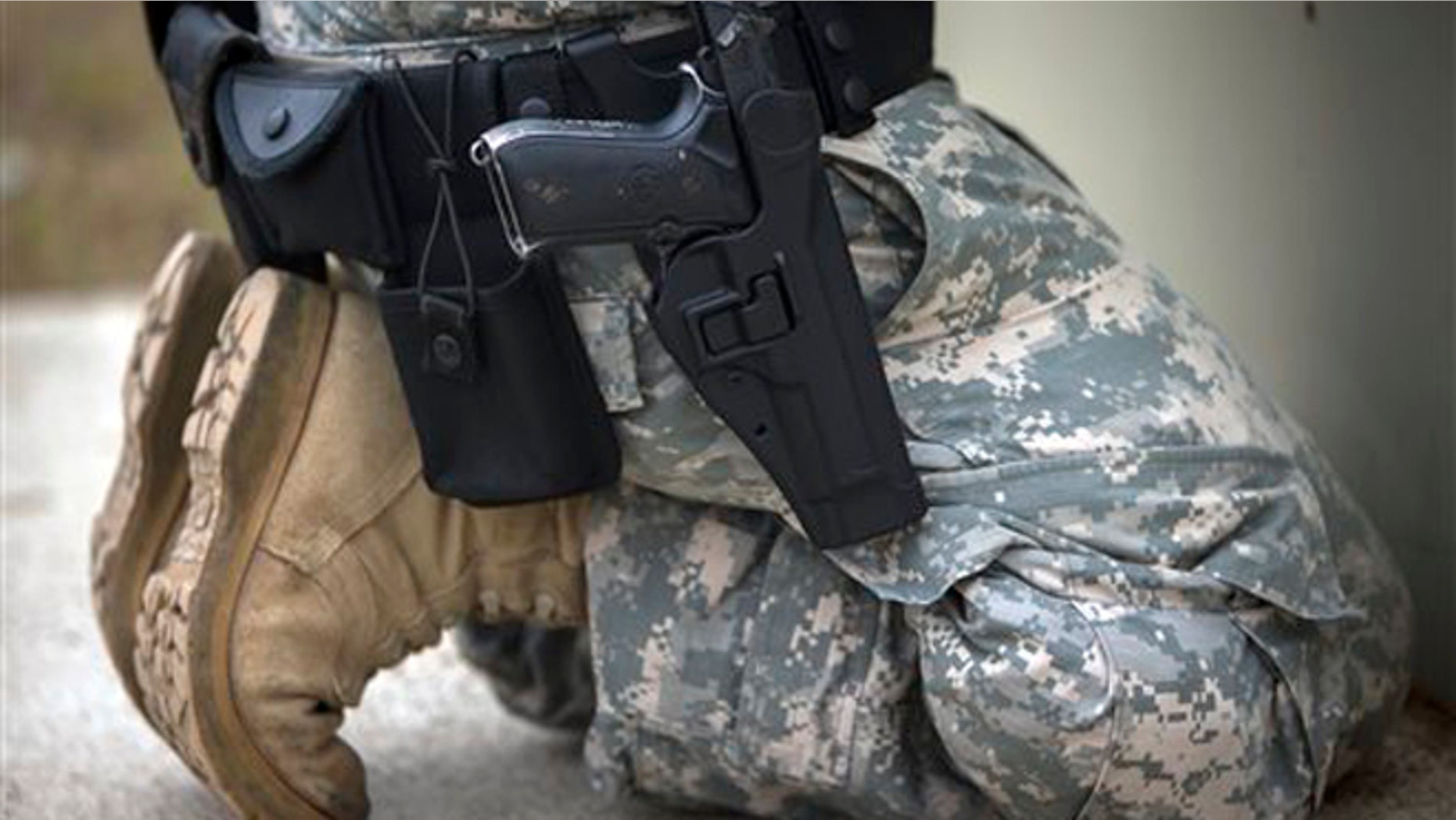 Sept. 29, 2015: A member of the 139th Military Police Company kneels with his holstered 9mm Beretta M9 during a qualifying exercise at a small arms range in Fort Stewart, Ga.