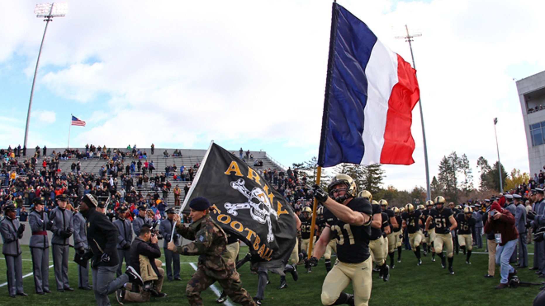 Nov 14, 2015; West Point, NY, USA; Army Black Knights defensive back Caleb McNeill (31) carries a French flag on to the field alongside a French exchange cadet before a game against the Tulane Green Wave at Michie Stadium.