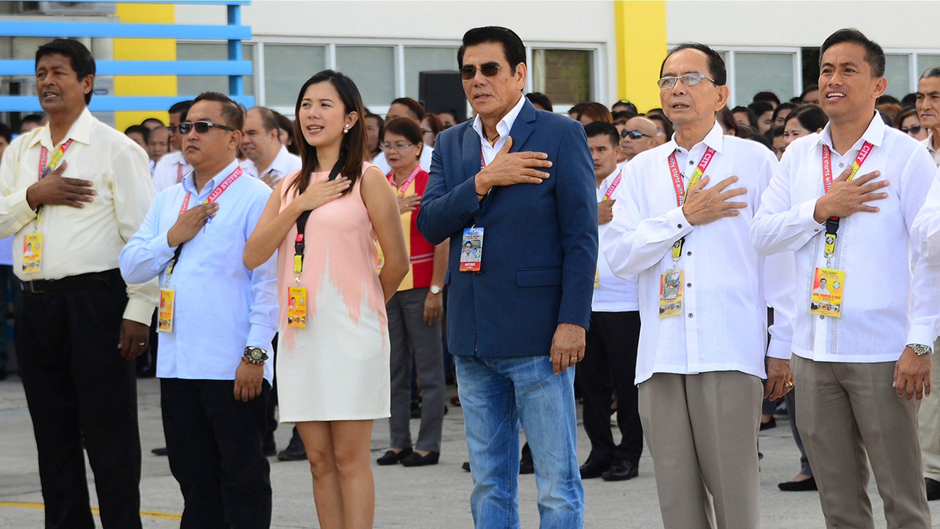 In this handout photo provided by the Tanuan City Information Office, Tanauan city Mayor Antonio Halili, third from right, attends a flag raising ceremony minutes before he was shot outside the municipal hall.