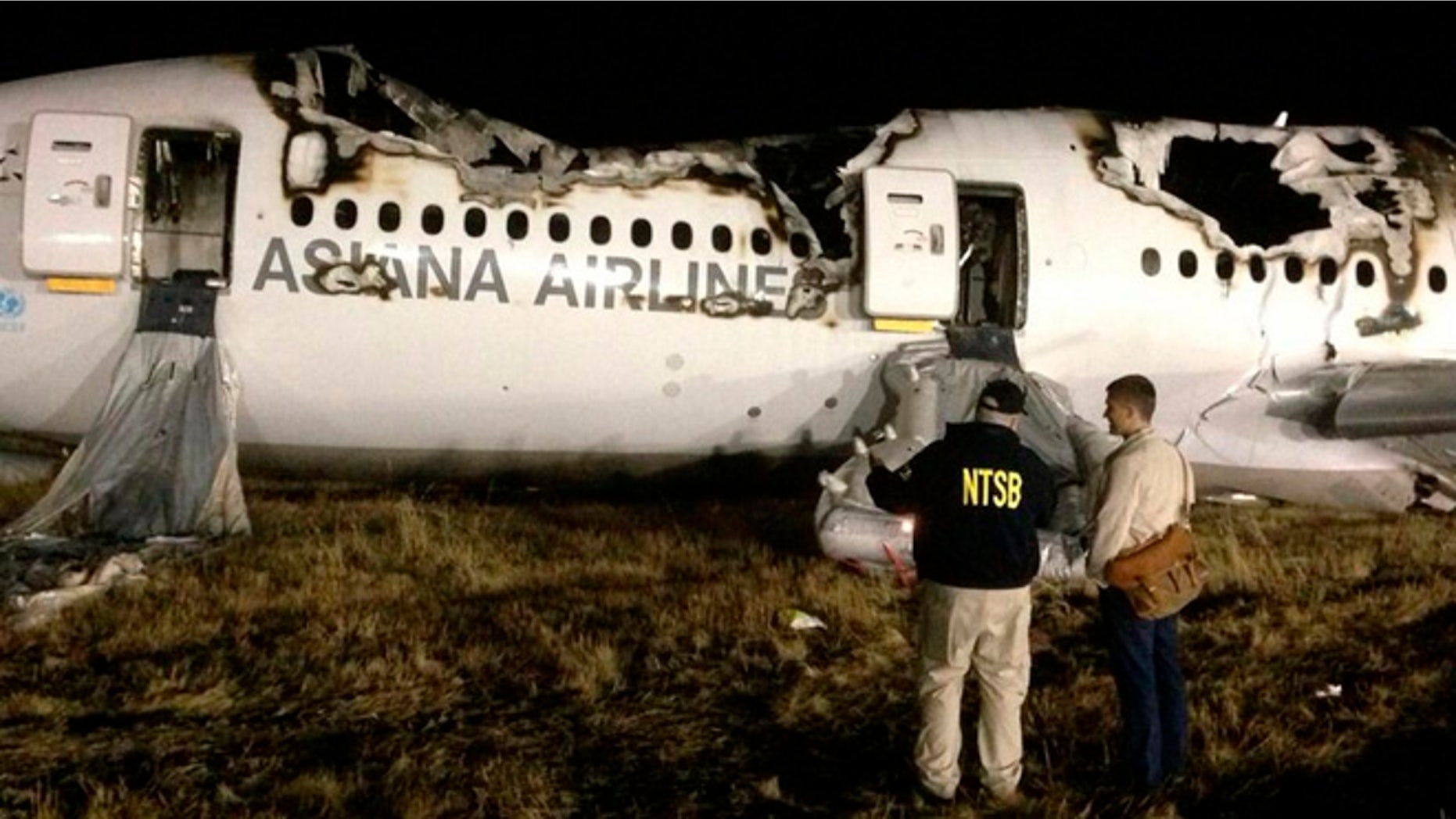 National Transportation Safety Board (NTSB) investigators conduct first site assessment of the wreckage of Asiana Airlines Flight 214, at San Francisco International Airport in San Francisco, California in this July 6, 2013 handout photo.