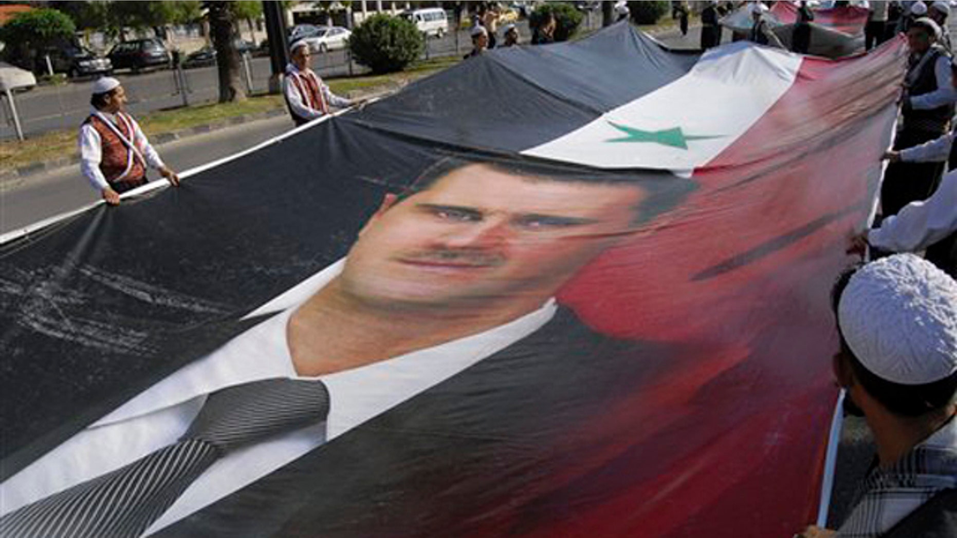 Supporters of Syrian President Bashar Assad carry a huge portrait of Assad as they march during a demonstration in his support in Damascus, Syria, June 8.