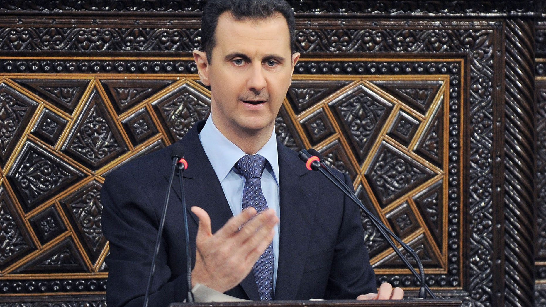 In this photo released by the Syrian official news agency SANA, shows Syrian President Bashar Assad, as he delivers a speech at the parliament in Damascus, Syria, Sunday, June 3, 2012. The president's first comments on the massacre expressed horror over the deaths of more than 100 people, nearly half of them children. U.N. investigators say there are strong suspicions that pro-government gunmen carried out the killings, but Assad denied that. (AP Photo/SANA)
