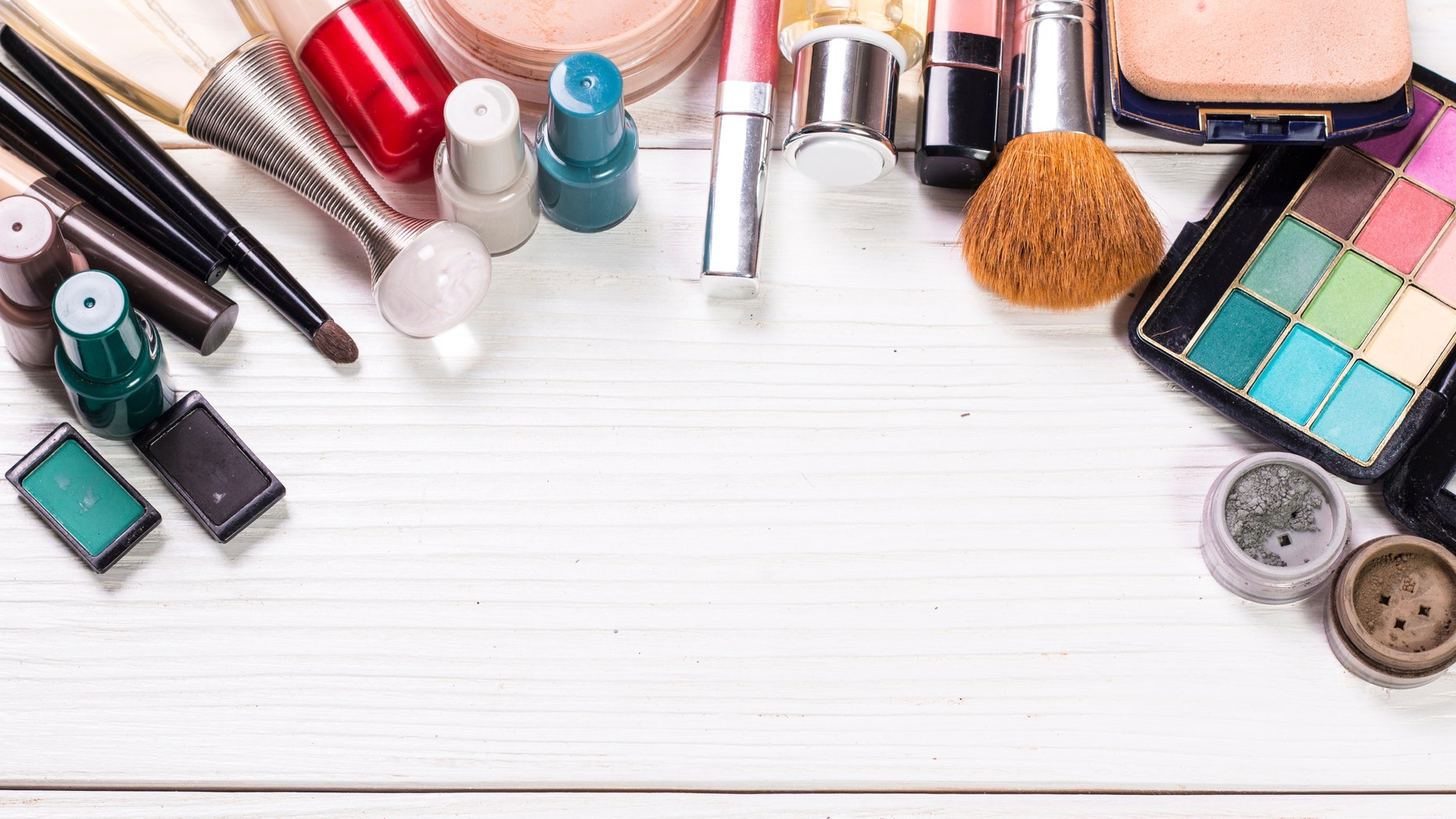 Various makeup products on dark background with copyspace