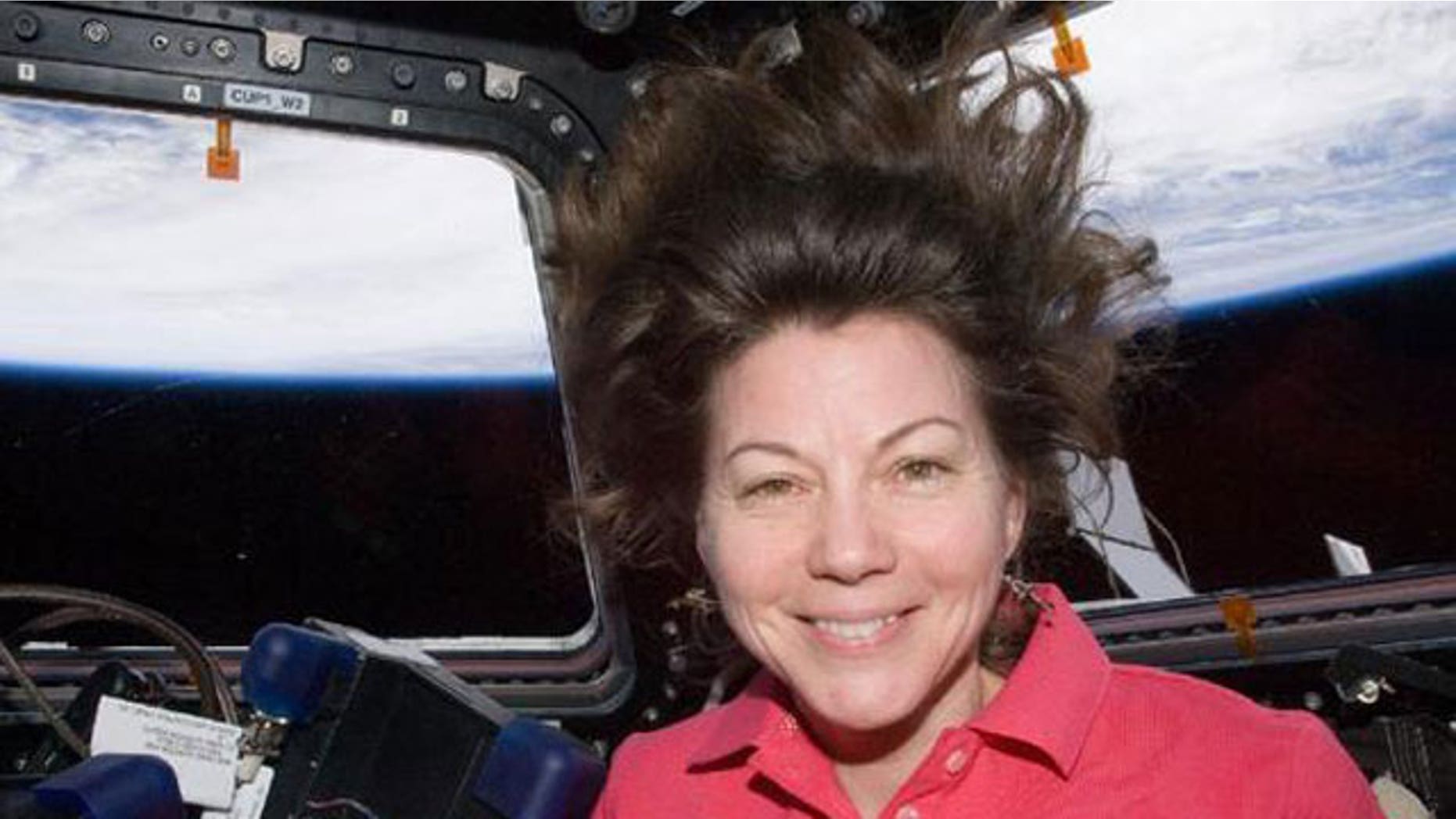 NASA astronaut Cady Coleman, Expedition 27 flight engineer, is pictured in the Cupola of the International Space Station. Earth’s horizon and the blackness of space are visible through the windows.
