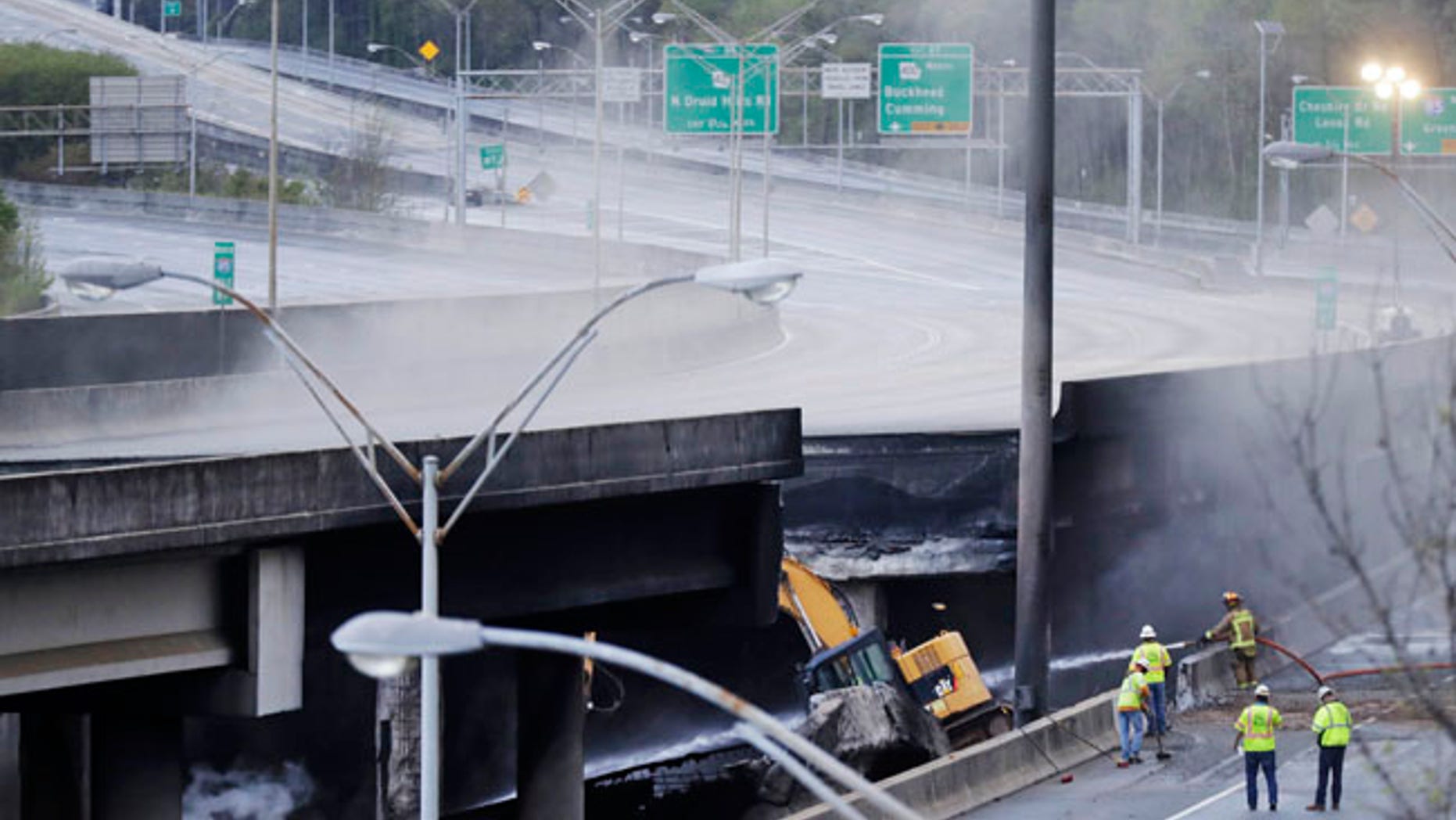 Crews work on a section of an overpass that collapsed from a large fire on Interstate 85 in Atlanta, Friday, March 31, 2017.