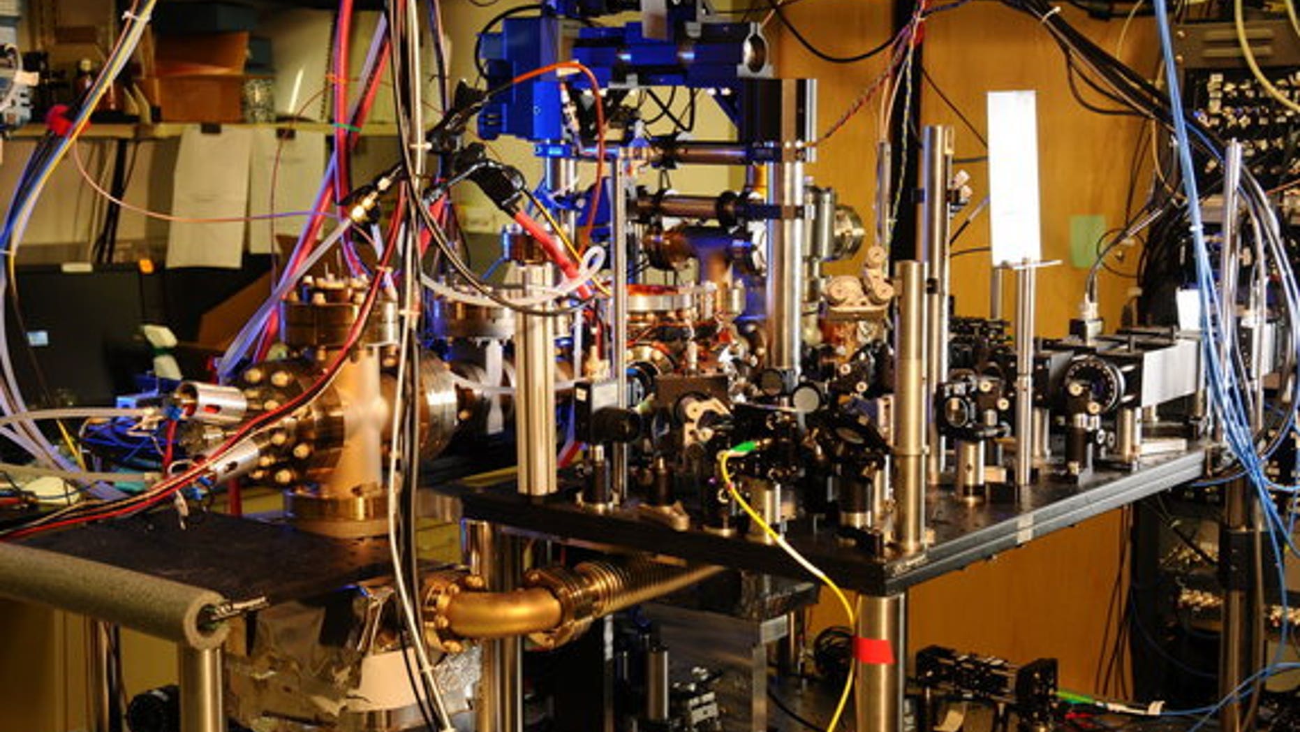 Scientists have designed a new atomic clock, using laser light and ytterbium atoms, that is ten times more stable than previously reported clocks. Ytterbium atoms are generated in an oven (large metal cylinder on the left) and sent to a vacuum
