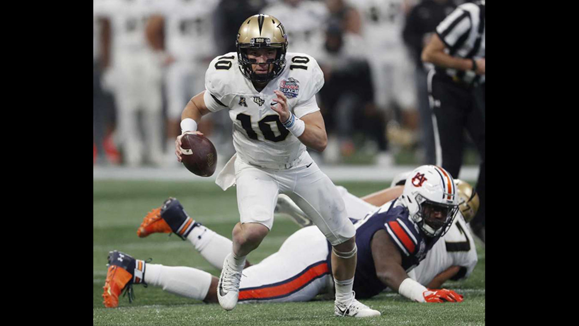 Central Florida quarterback McKenzie Milton (10) runs out of the pocket against Auburn during the first half of the Peach Bowl NCAA college football game Monday in Atlanta. (AP Photo/John Bazemore)