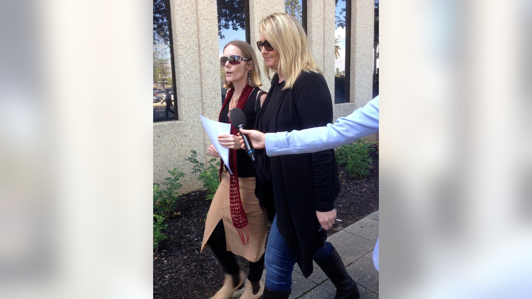 Angela Kiszko, left, walks with an unidentified woman after leaving a court house in Perth, Australia, on Friday, May 20, 2016, after a judge ruled in favor of a couple who refused to allow their 6-year-old son to undergo radiotherapy for a malignant brain tumor. Princess Margaret Hospital in Perth had applied for a Family Court order forcing Kiszko's son, Oshin, to undergo radiotherapy for a rare cancer known as medulloblastoma that was diagnosed in December.