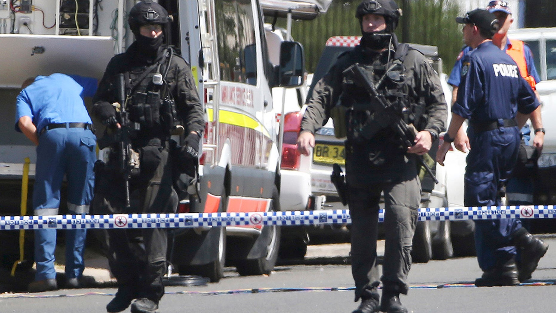March 7, 2016: Police Tactical Group officers walk on a cordoned off street of an industrial section of Ingleburn, in suburban Sydney, as police respond to a shooting. (AP Photo/Rick Rycroft)