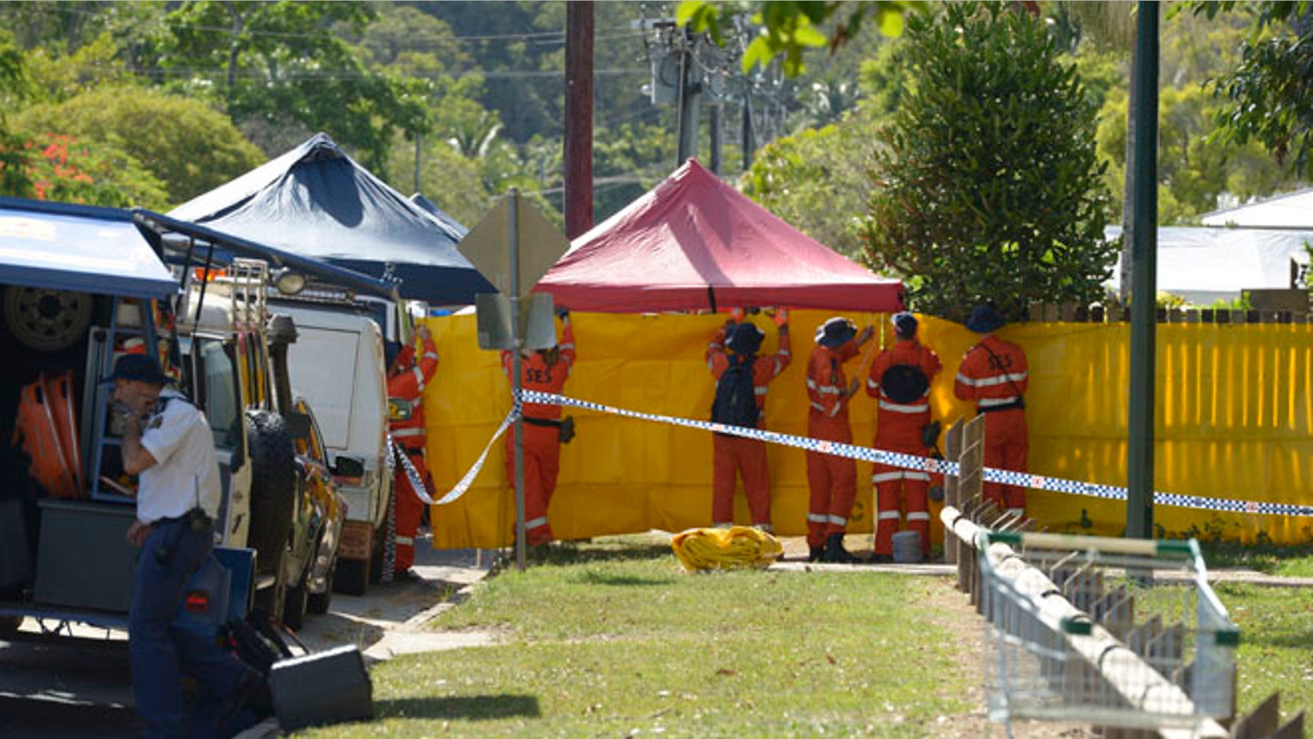 Dec. 19, 2014: Emergency services workers cover off the perimeter fence of a house where eight children have been found dead in a Cairns suburb in far north Queensland, Australia. (AP)