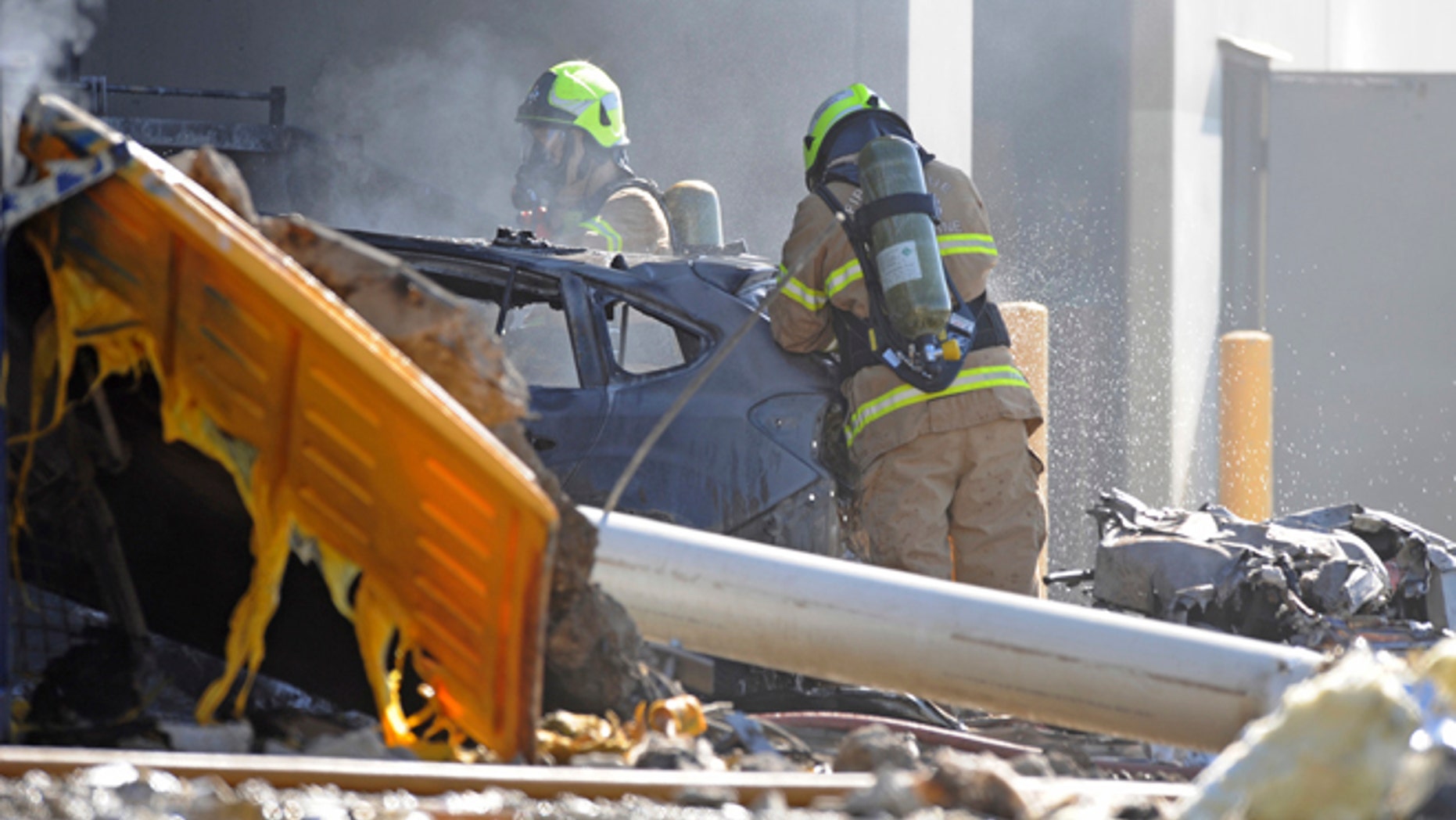 Emergency personnel work at the scene where a light plane crashed in Melbourne.