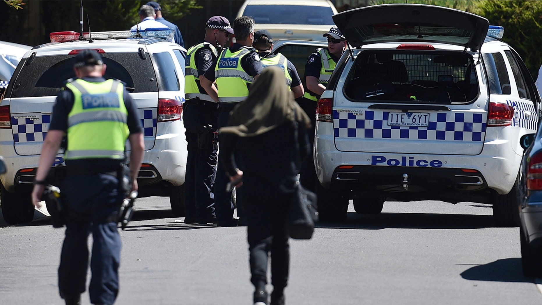 Dec. 23, 2016: Police accompany a woman as they attend the scene where a house was raided at Meadow Heights in Melbourne, Australia.