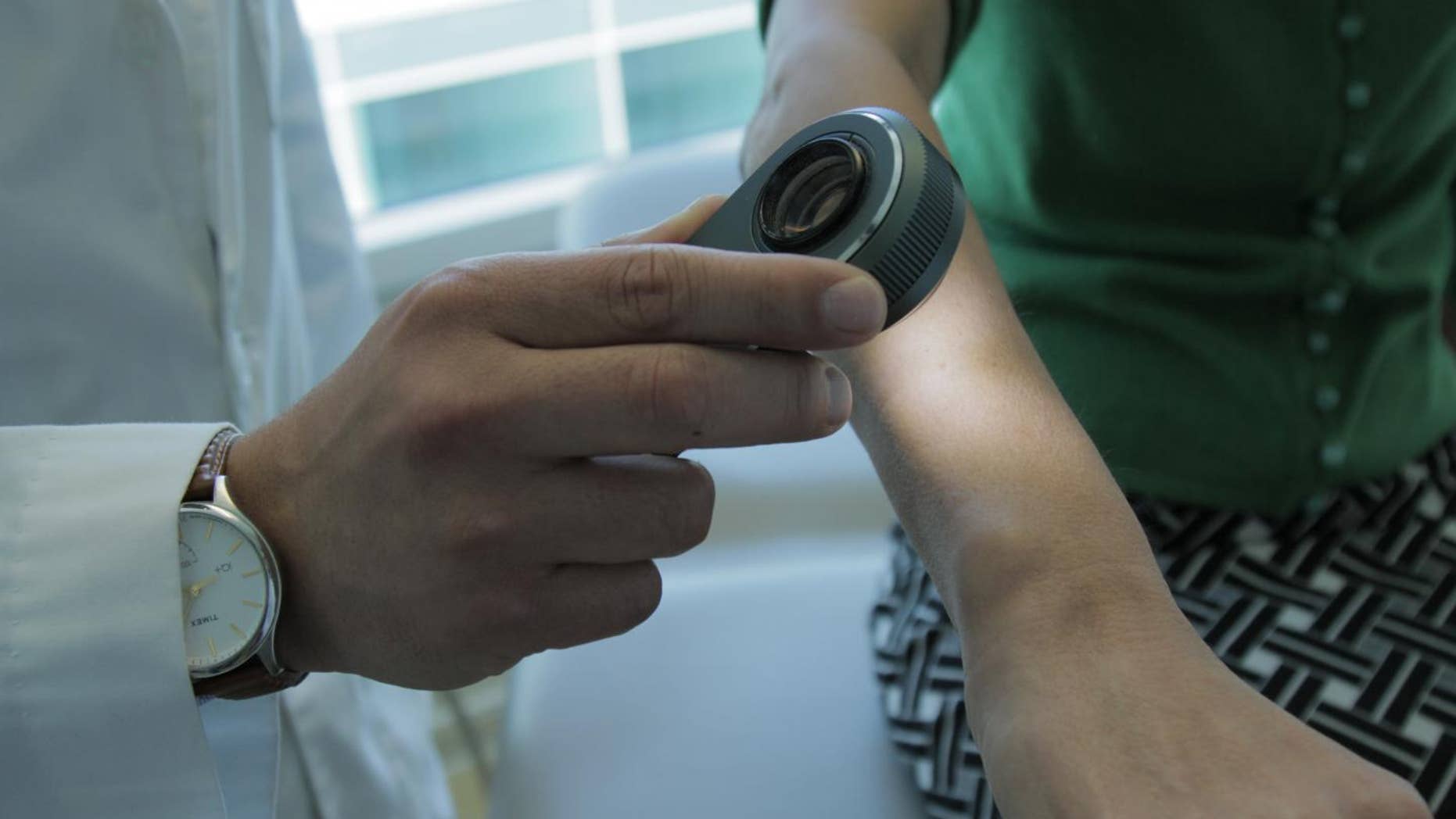 This is a dermatologist using a dermatoscope, a type of handheld microscope, to look at skin. Computer scientists at Stanford have created an artificially intelligent diagnosis algorithm for skin cancer that matched the performance of board-certified dermatologists.