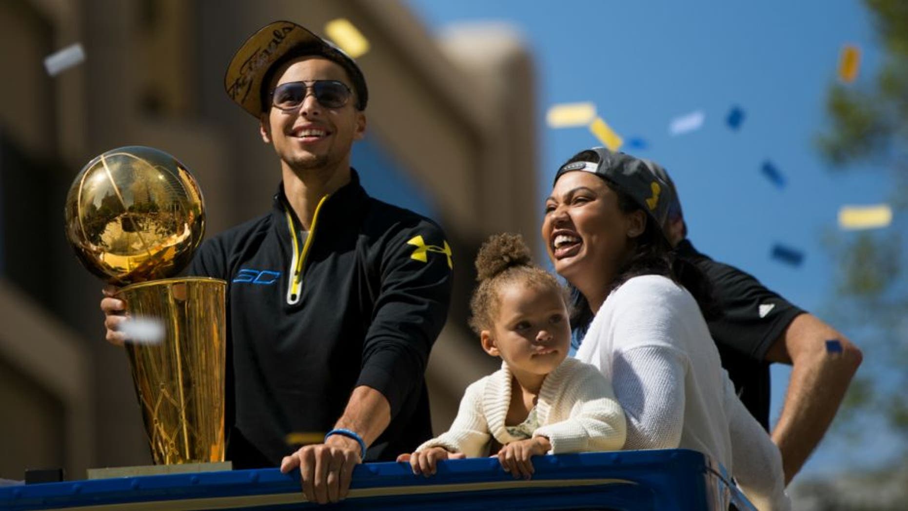 OAKLAND, CA - JUNE 19: (L-R) Stephen Curry #30 of the Golden State Warriors, daughter Riley and wife Ayesha smile during the Golden State Warriors Victory Parade in Oakland, California. Thousands are expected to attend in celebration of the Warriors' first NBA title in 40 years. (Photo by Stephen Lam/Getty Images)