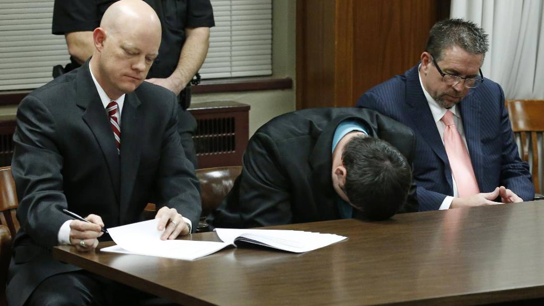 Daniel Holtzclaw, center, puts his head on the table and cries as the verdicts are read in his trial in Oklahoma City, Thursday, Dec. 10, 2015. At left is defense attorney Robert Gray and at right is defense attorney Scott Adams. Holtzclaw, a former Oklahoma City police officer, was facing dozens of charges alleging he sexually assaulted 13 women while on duty. Holtzclaw was found guilty on a number of counts. (AP Photo/Sue Ogrocki, Pool)