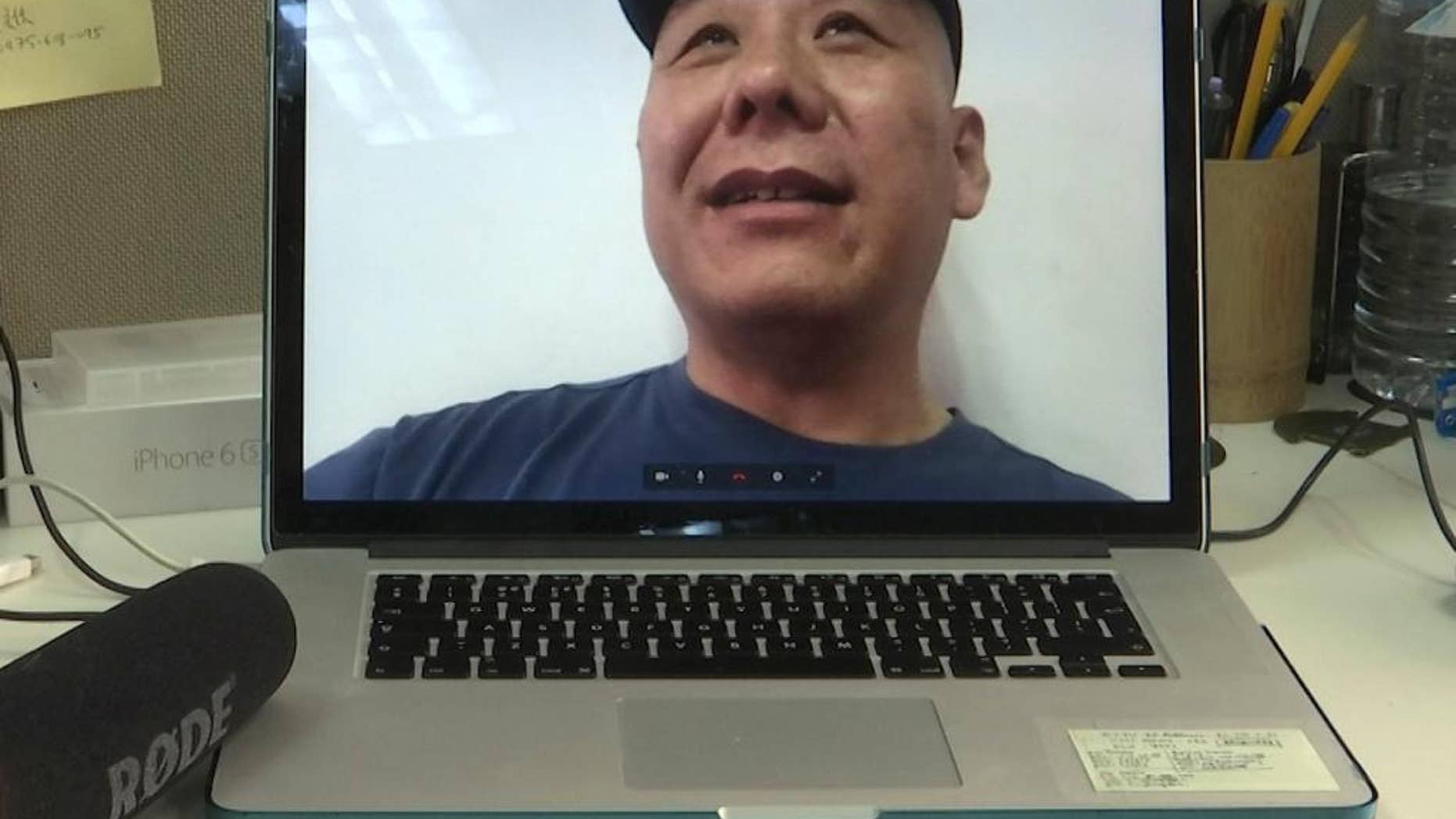 Chinese dissident Zhang Xiangzhong is seen on a computer screen during an interview via videoconference Monday, April 17, 2017, in Taipei, Taiwan. Zhang, who abandoned his tour group while in Taiwan, said he will apply for political asylum on Tuesday in hopes of staying on the self-governing island to promote democracy on the mainland. (AP Photo/Johnson Lai)