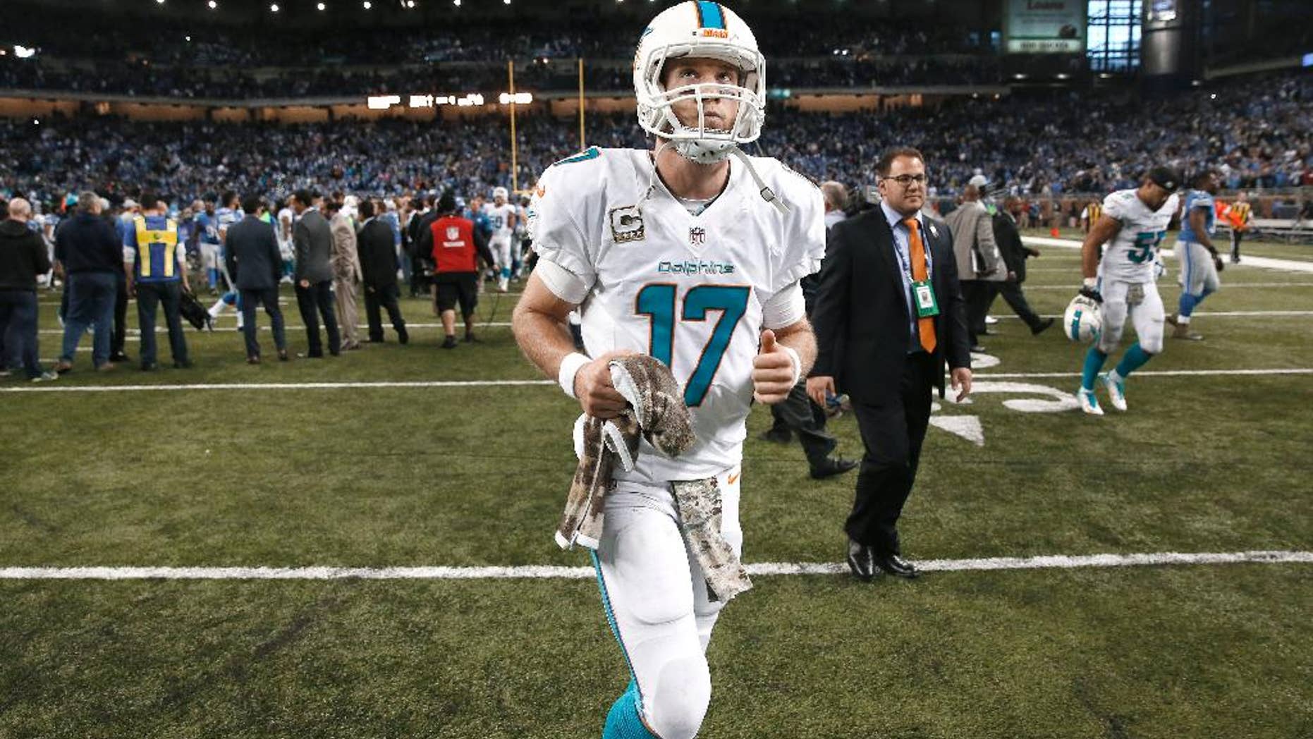 Miami Dolphins quarterback Ryan Tannehill runs off the field after losing to the Detroit Lions 20-16 in an NFL football game in Detroit, Sunday, Nov. 9, 2014. (AP Photo/Paul Sancya)