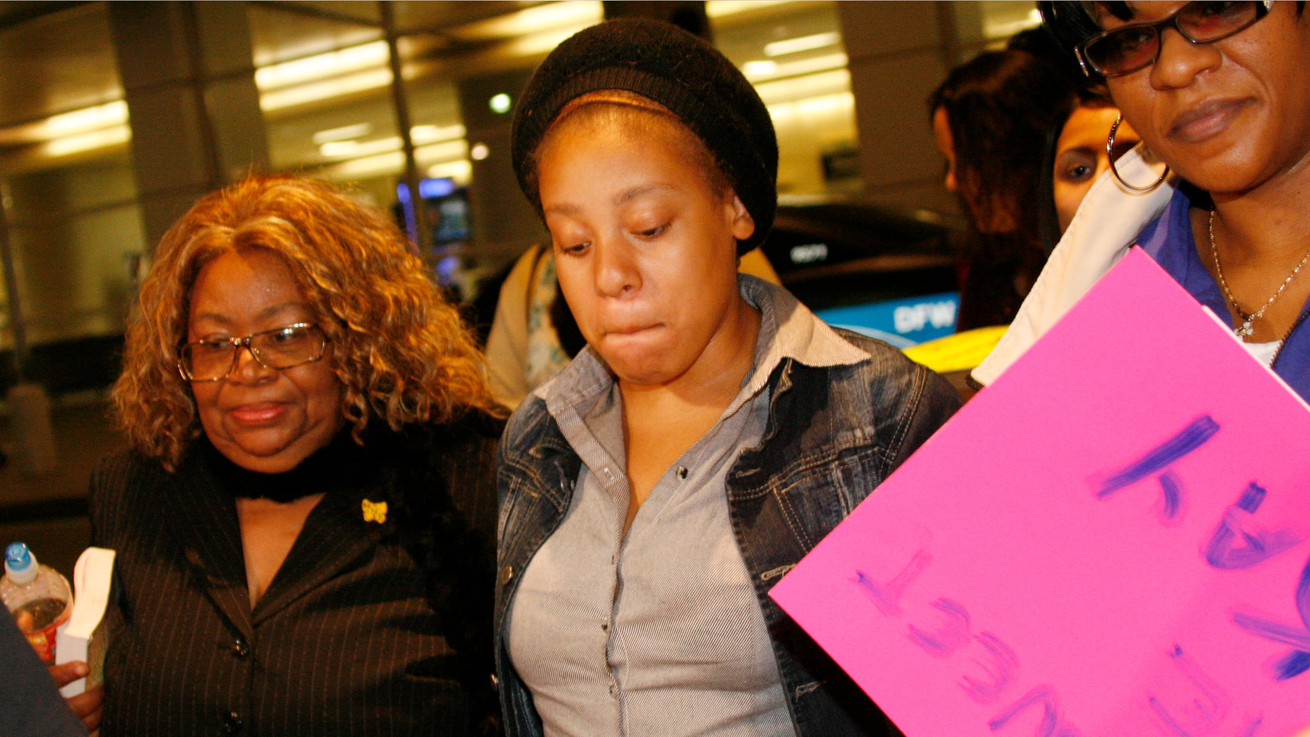 Jakadrien Turner, age 15, center, walks with her grandmother Lorene Turner, left, and mother Johnisa Turner, right, all of Dallas, at DFW Airport in Fort Worth, Texas, on Friday Jan. 6, 2012. (AP Photo/Mike Fuentes)