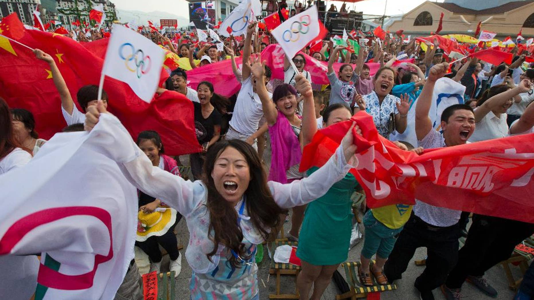 Residents celebrate as Beijing is announced as the host city for the 2022 Winter Olympics at the ski resort region of Chongli where the Nordic skiing, ski jumping, and other outdoor Olympic events will be held in northern China's Hebei province Friday, July 31, 2015. Beijing was selected Friday to host the 2022 Winter Olympics, becoming the first city awarded both the winter and summer games. (AP Photo/Ng Han Guan)