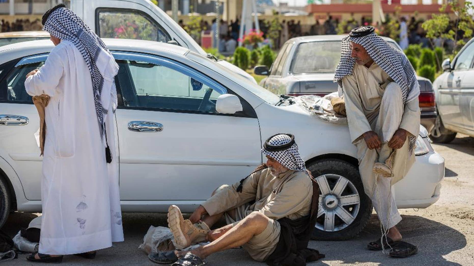 Members of an Iraqi volunteer force put on their newly issued boots in the Shiite holy city of Karbala, 50 miles (80 kilometers) south of Baghdad, Iraq, Tuesday, June 24, 2014. Iraq's top Kurdish leader warned visiting Secretary of State John Kerry on Tuesday that a rapid Sunni insurgent advance has already created "a new reality and a new Iraq," signaling that the U.S. faces major difficulties in its efforts to promote unity among the country's divided factions. The U.N., meanwhile, said more than 1,000 people, most civilians, have been killed in Iraq so far this month, the highest death toll since the U.S. military withdrew from the country in December 2011. (AP Photo/Ahmed al-Husseini)