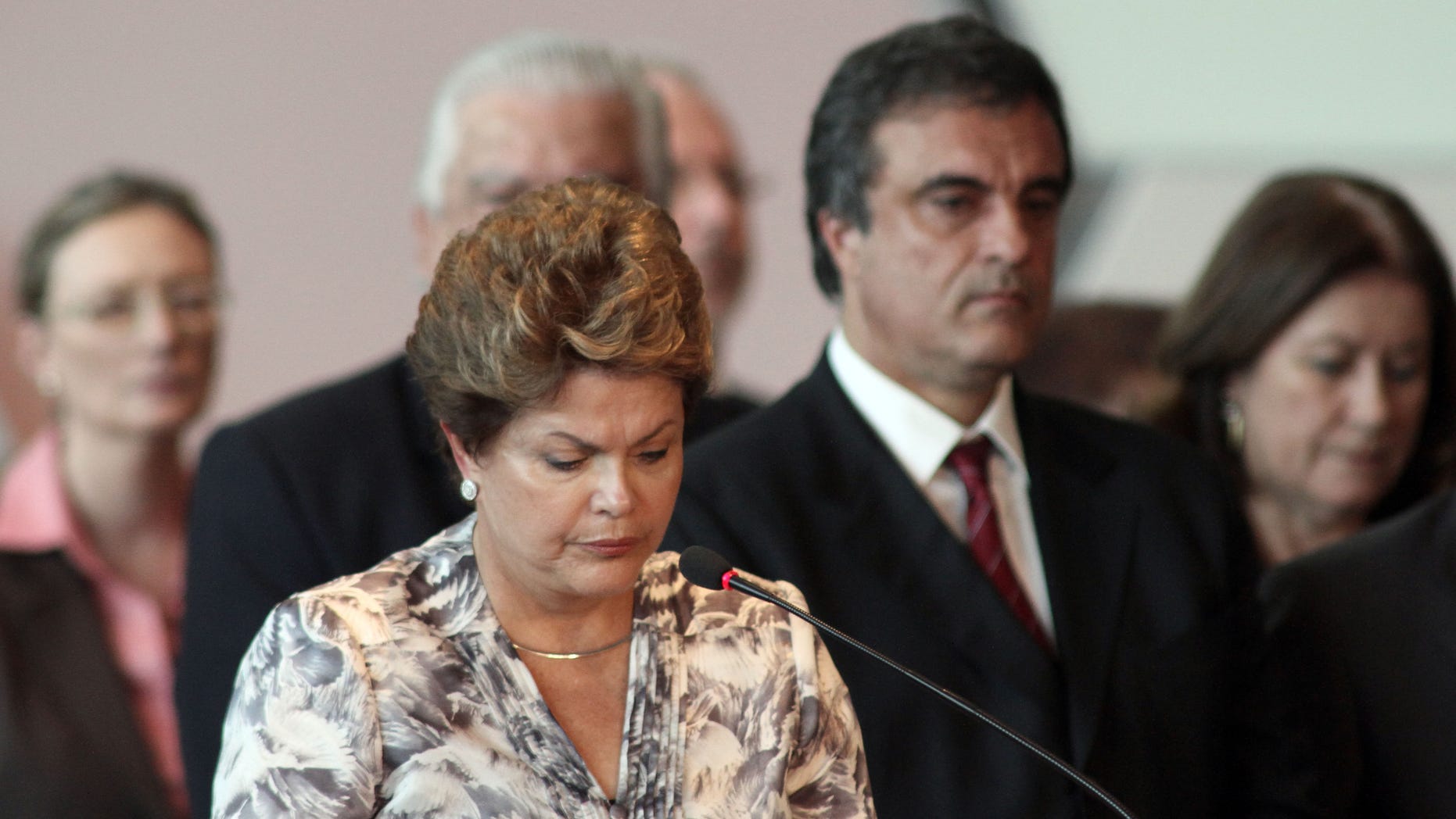 Brazil's President Dilma Rousseff, front, stands a minute of silence for the victims of a deadly fire at a nightclub during a meeting with mayors who recently took office in Brasilia, Brazil, Monday, Jan. 28, 2013. A blaze raced through a crowded nightclub in southern Brazil early Sunday, killing more than 230 people as the air filled with deadly smoke and panicked party-goers stampeded toward the exits, police and witnesses said. (AP Photo/Eraldo Peres)