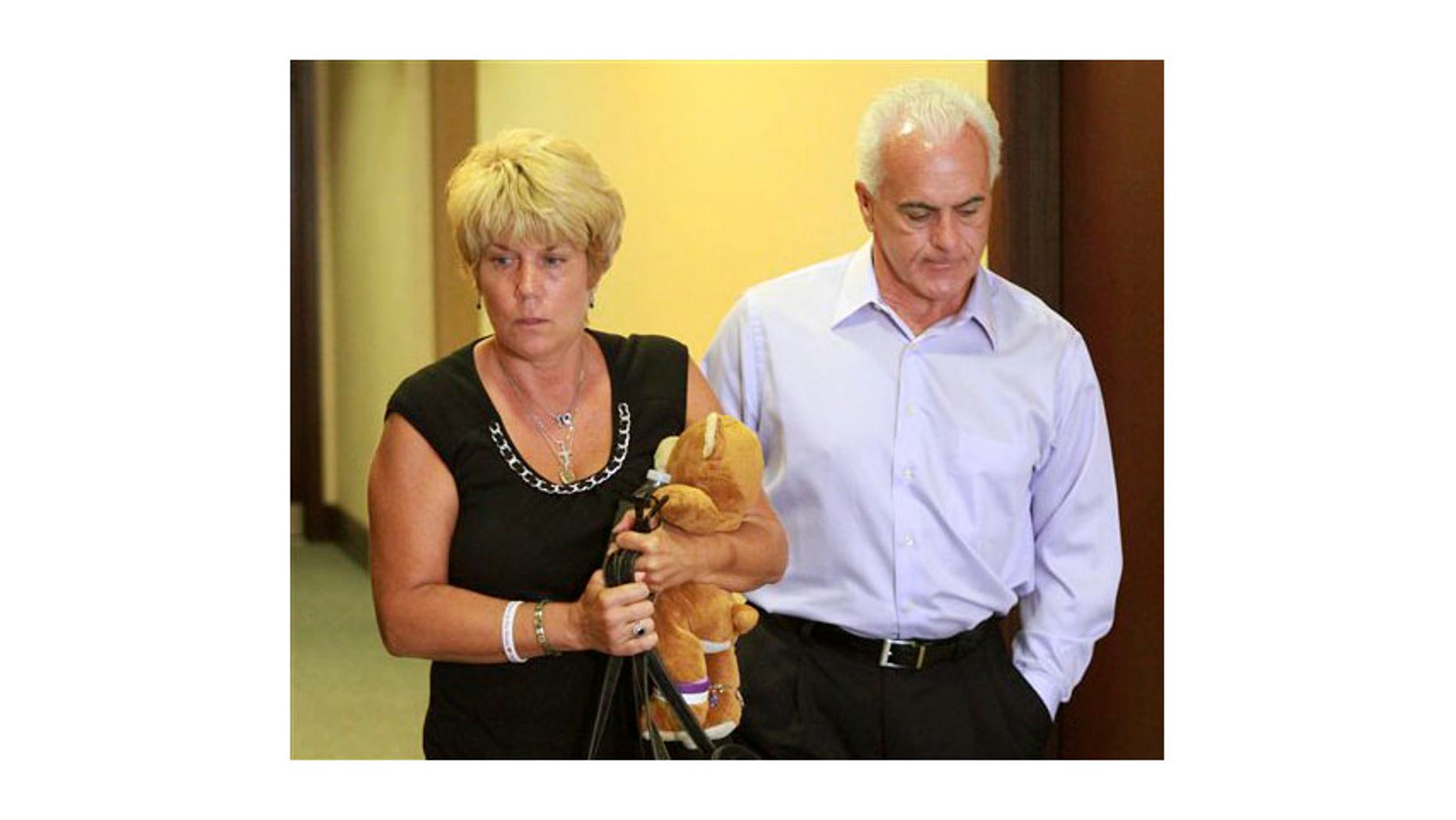 May 24: Cindy Anthony, holding a teddy bear, and her husband, George Anthony, leave the courtroom after listening to the first part of the state's opening arguments in their daughter's first-degree murder trial, at the Orange County Courthouse, in Orlando, Fla.
