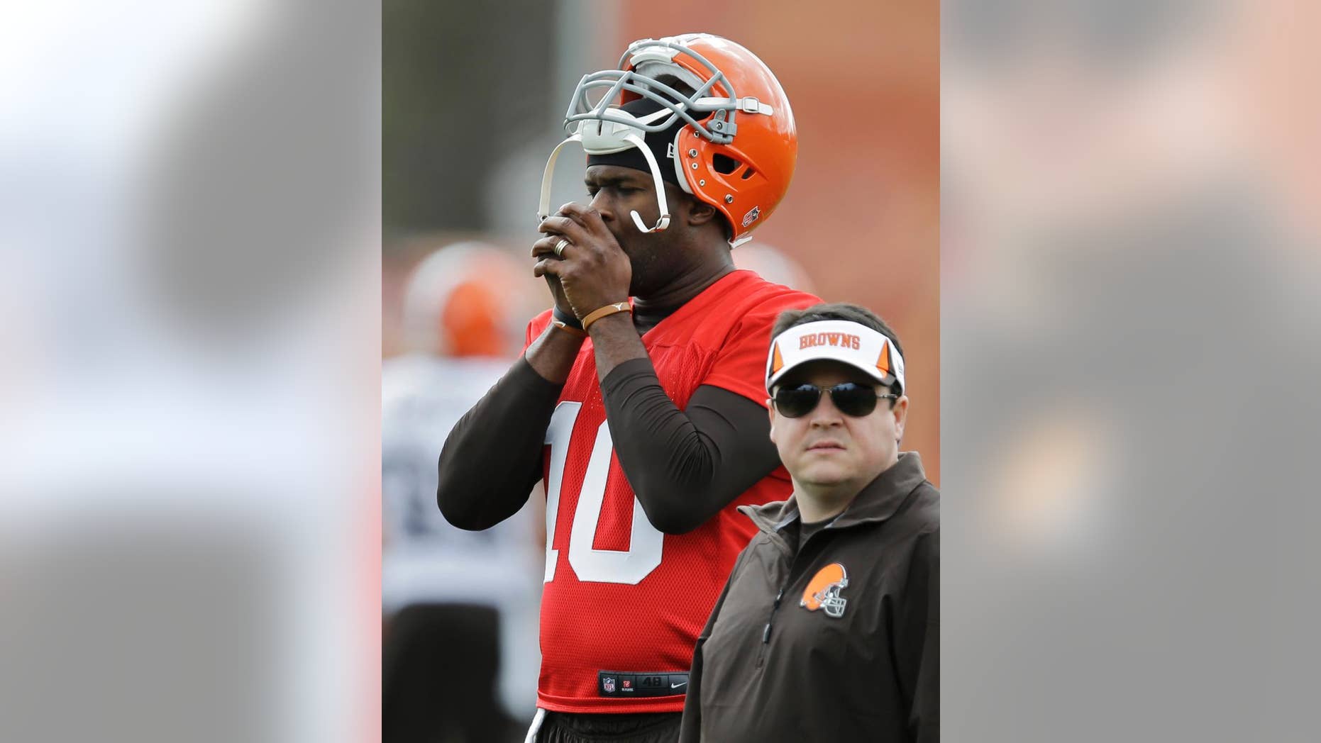 Cleveland Browns quarterback Vince Young warms his hands during a voluntary minicamp workout at the NFL football team's facility in Berea, Ohio Thursday, May 1, 2014. (AP Photo/Mark Duncan)