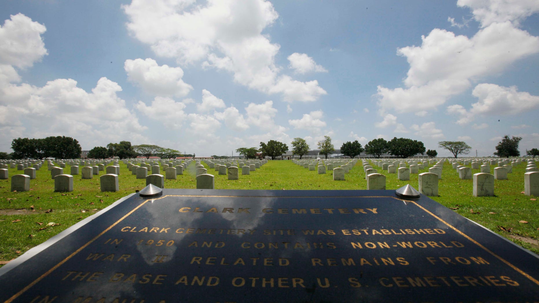 FILE - In this In this July 1, 2011 file photo, a Clark Veterans Cemetery marker faces more than 8,000 tombstones at the sprawling Clark Economic Zone, a former U.S. Air Force base in Dau, Pampanga province in northern Philippines. U.S. and Philippine officials signed an agreement Monday, Dec. 16, 2013, allowing Washington to restore the cemetery where the graves of thousands of American servicemen and dependents have been covered in ash since Mount Pinatubo's 1991 eruption. (AP Photo/Bullit Marquez, File)