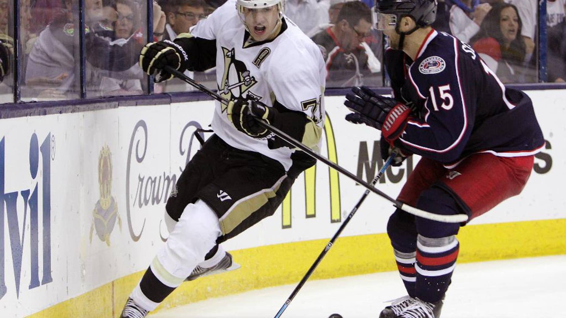 Pittsburgh Penguins' Evgeni Malkin, left, of Russia, chases the puck as Columbus Blue Jackets' Nick Shultz defends during the third period of Game 6 of a first-round NHL playoff hockey series Monday, April 28, 2014, in Columbus, Ohio. The Penguins advance to the second round with their 4-3 win over the Blue Jackets. (AP Photo/Jay LaPrete)