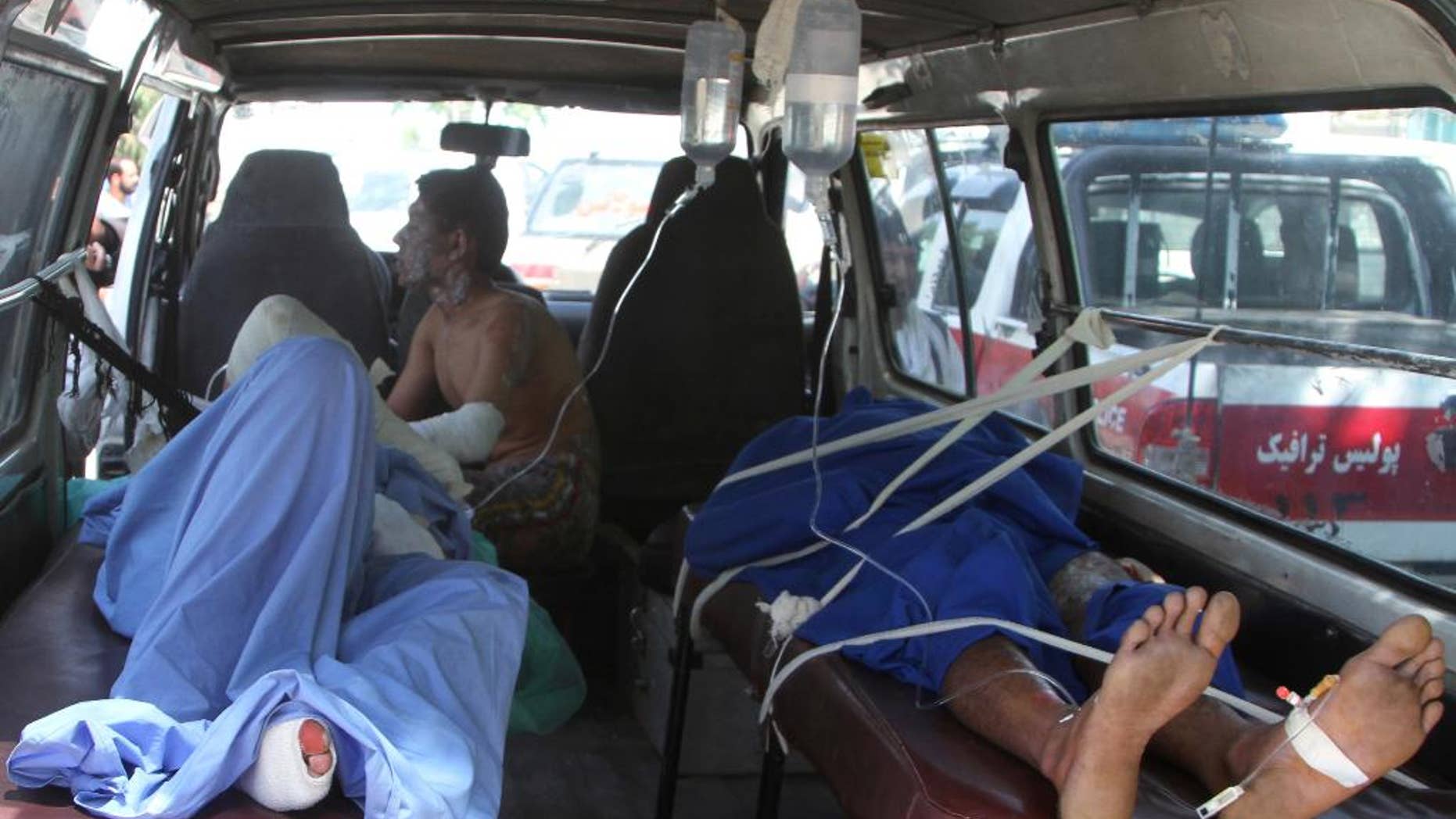 Injured Afghan men lie in an ambulance after an accident on the main highway linking the capital, Kabul, to the southern city of Kandahar, in Ghazni province eastern of Kabul, Afghanistan, Sunday, May 8, 2016. Officials say two buses and a fuel tanker have collided on a major highway in Afghanistan, killing at least 14 people. Dozens more people were wounded in the accident, which set all three vehicles ablaze, and the death toll is expected to rise. (AP Photo/Rahmatullah Nikzad)