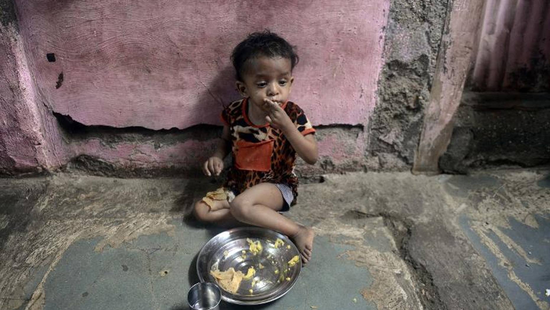 A malnourished Indian child finishes her lunch consisting of a special supplementary diet at the Nutrition Rehabilitation Centre (NRC) of Apnalaya, an Indian NGO providing nutritious free meals at Govandi on the outskirts of Mumbai, on April 18, 2013