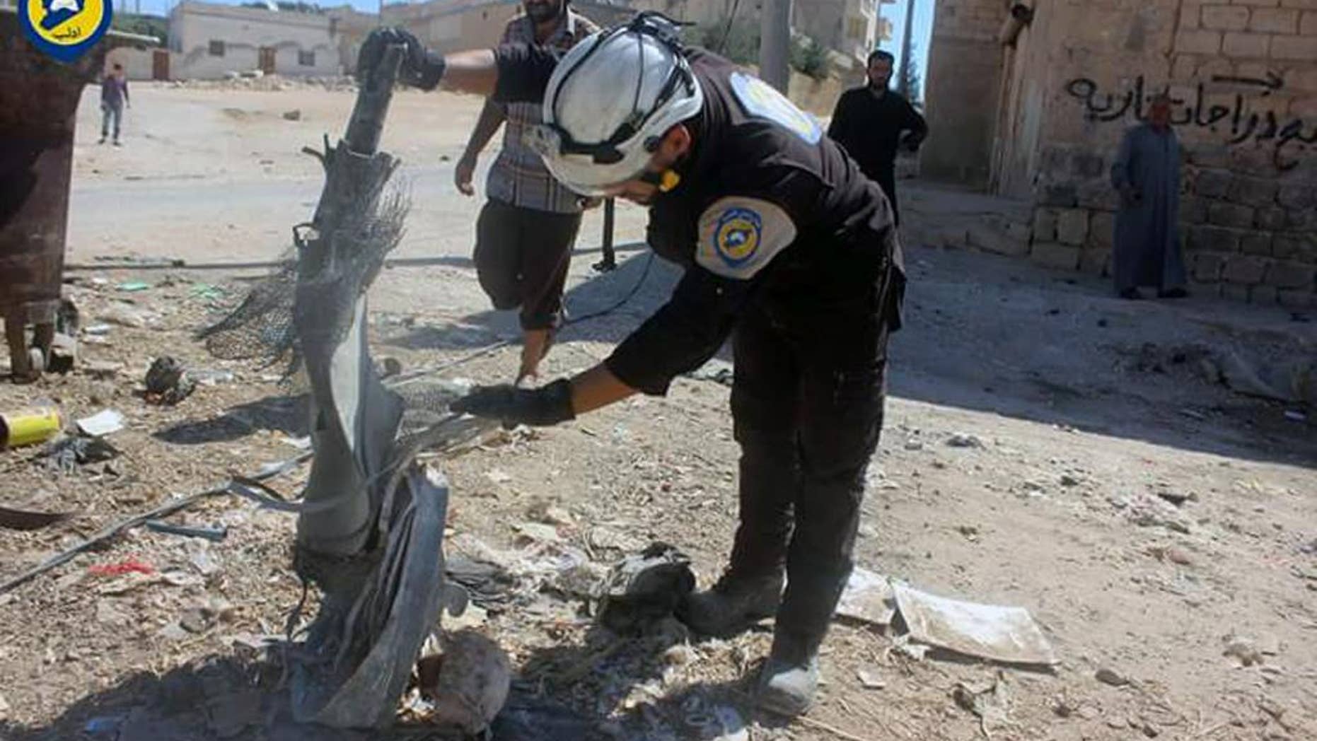 In this photo provided by the Syrian Civil Defense group known as the White Helmets, shows members of Civil Defense inspecting the cluster bombs in the Khan Sheikhoun neighborhood of Idlib, Syria, Thursday, Sept. 29, 2016. The U.S. and Russia escalated their war of words over Syria Thursday as government forces kept up their assault on Aleppo's rebel-held quarters and registered tenuous gains. (Syrian Civil Defense White Helmets via AP)