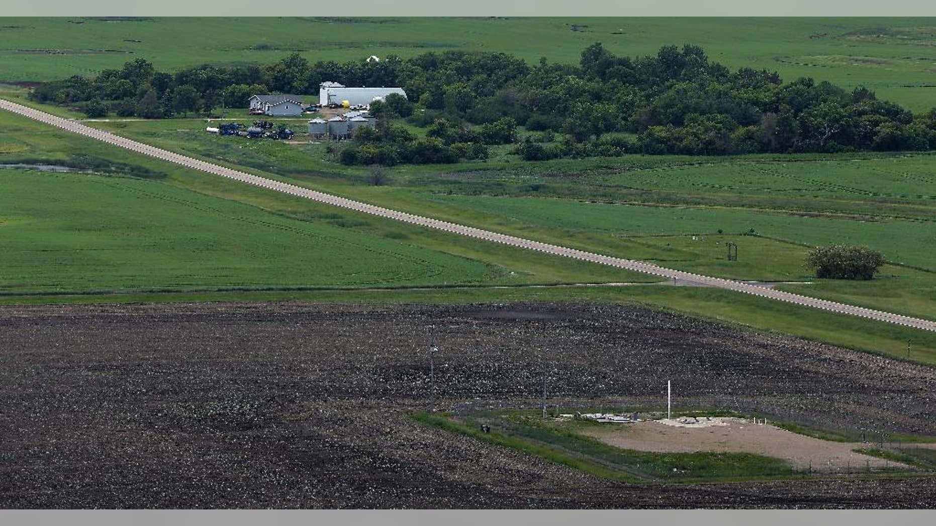 FILE - This June 24, 2014 file photo, shows an ICBM launch site located among fields and farms in the countryside outside Minot, N.D. The Air Force on Monday, Nov. 3, 2014, fired two more nuclear commanders and disciplined a third. The actions were confirmed to the Associated Press in response to an AP inquiry about an internal Air Force investigation of two commanders at the 91st Missile Wing at Minot Air Force Base, N.D., which also is responsible for 150 Minuteman 3 missiles. (AP Photo/Charlie Riedel, File)