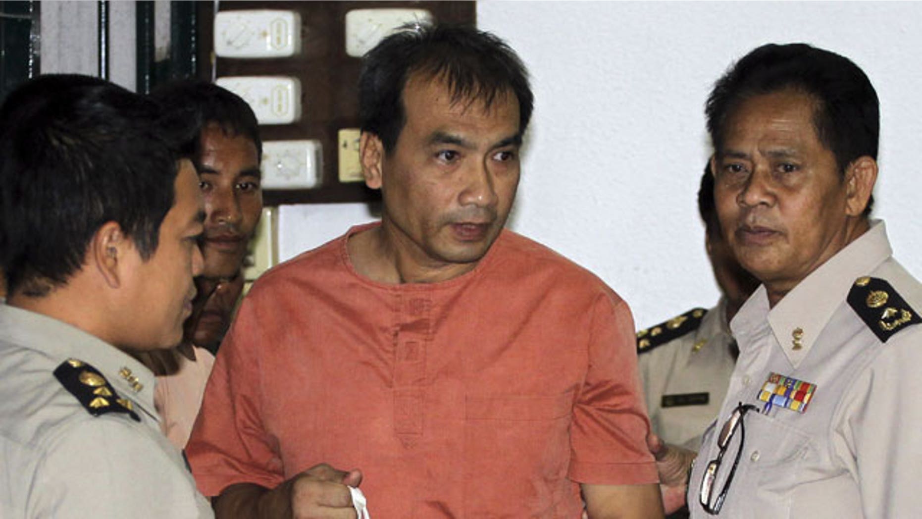 December 8, 2011: Joe Gordon, a Thai-born American, center, is escorted by correction officials at a criminal court in Bangkok, Thailand.