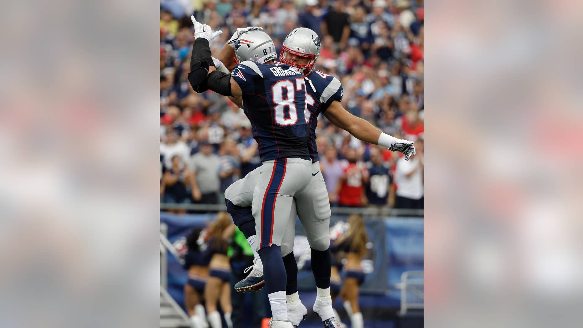New England Patriots tight end Rob Gronkowski (87) celebrates his touchdown catch with fullback James Develin, rear, in the first half of an NFL football game against the Oakland Raiders, Sunday, Sept. 21, 2014, in Foxborough, Mass. (AP Photo/Steven Senne)