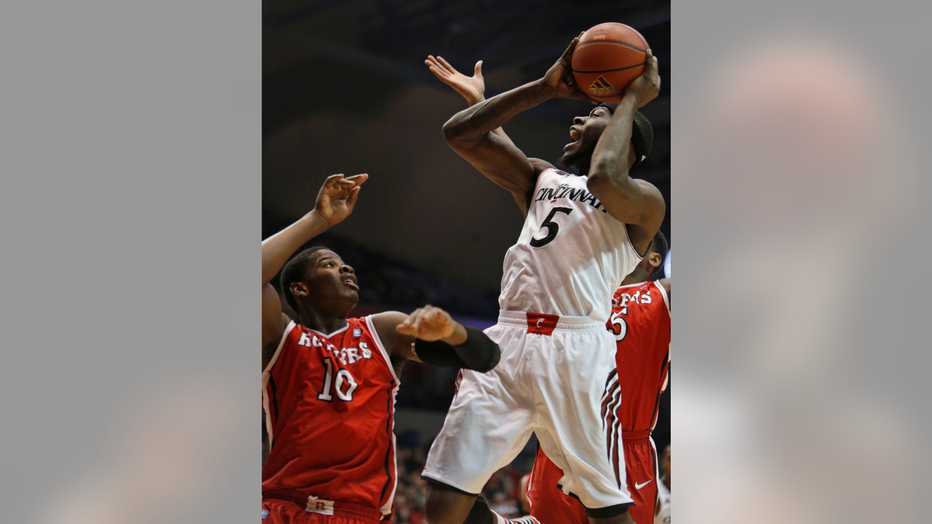 Cincinnati forward Justin Jackson (5) looks to shoot against Rutgers forward Junior Etou (10) during the first half of an NCAA college basketball game, Saturday, Jan. 11, 2014, in Cincinnati. (AP Photo/David Kohl)