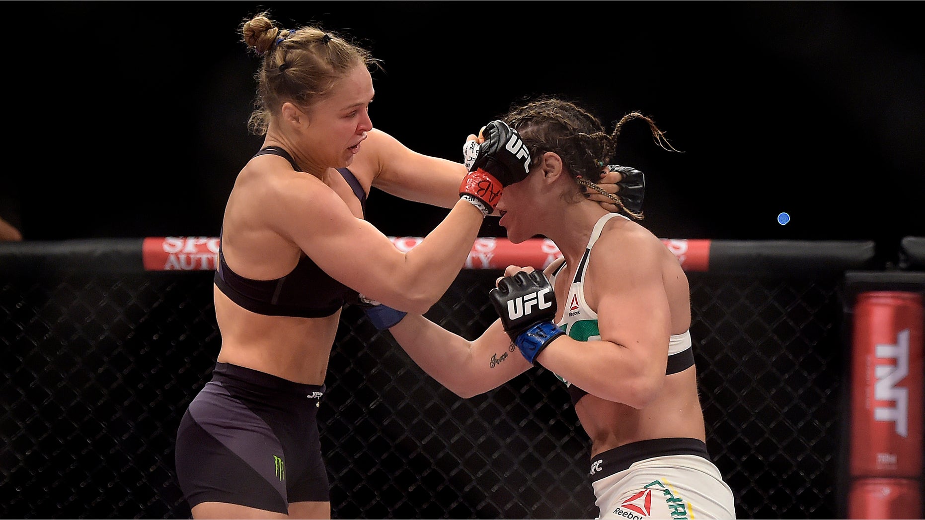 In this photo released by Inovafoto, Ronda Rousey, left, of the United States, battles Brazil's Bethe Correia during their mixed martial arts bantamweight title fight at UFC 190, early Sunday, Aug. 2, 2015, in Rio de Janeiro, Brazil. Rousey knocked out Correia 34 seconds into the first round to win. (Alexandre Loureiro/Inovafoto via AP)
