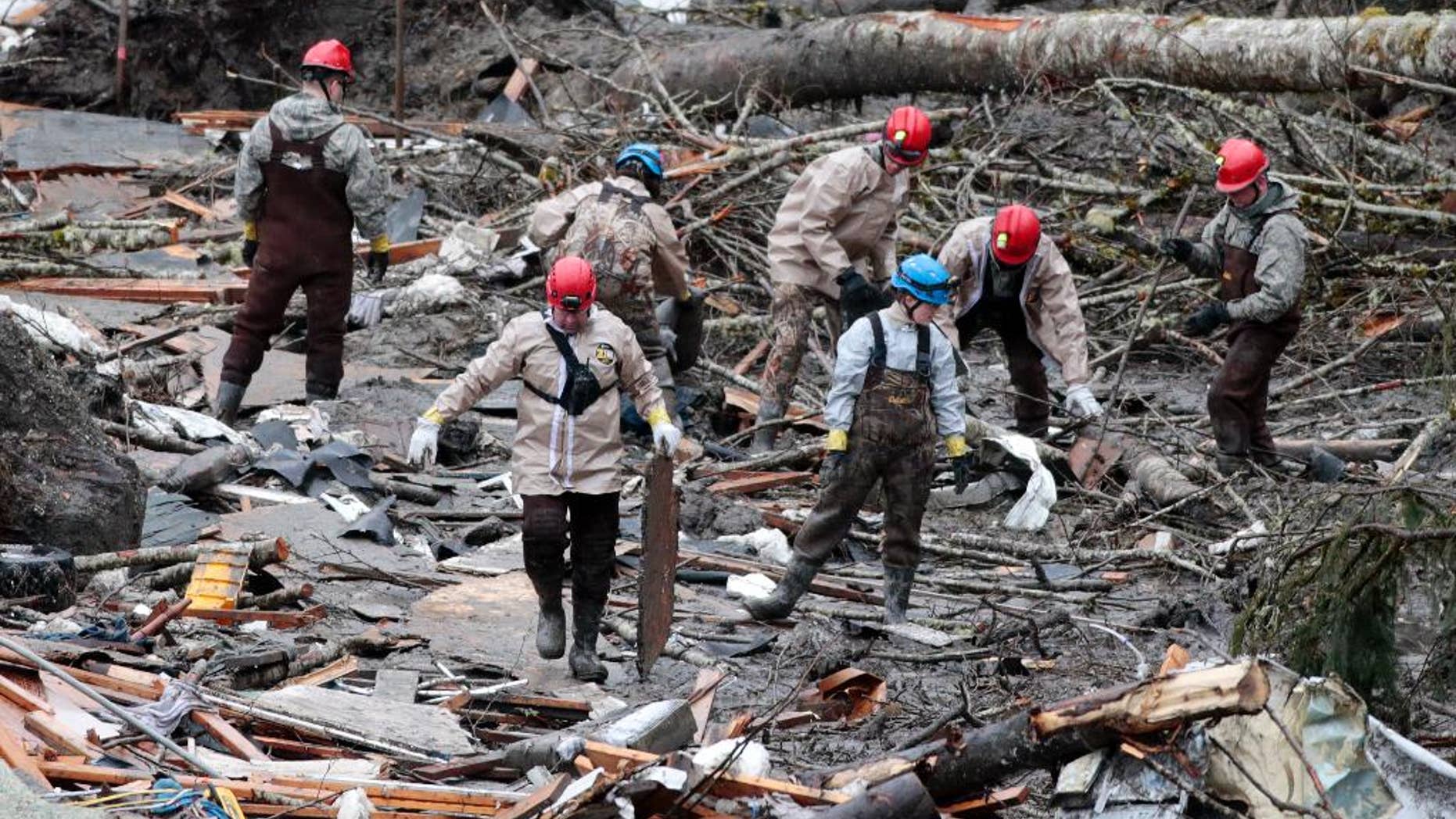 Workers comb through debris at the site of a deadly mudslide, Friday, March 28, 2014, in Oso, Wash. Besides the 26 bodies already found, dozens more people could be buried in the debris pile left from the mudslide nearly one week ago. (AP Photo/Lindsey Wasson, Pool)