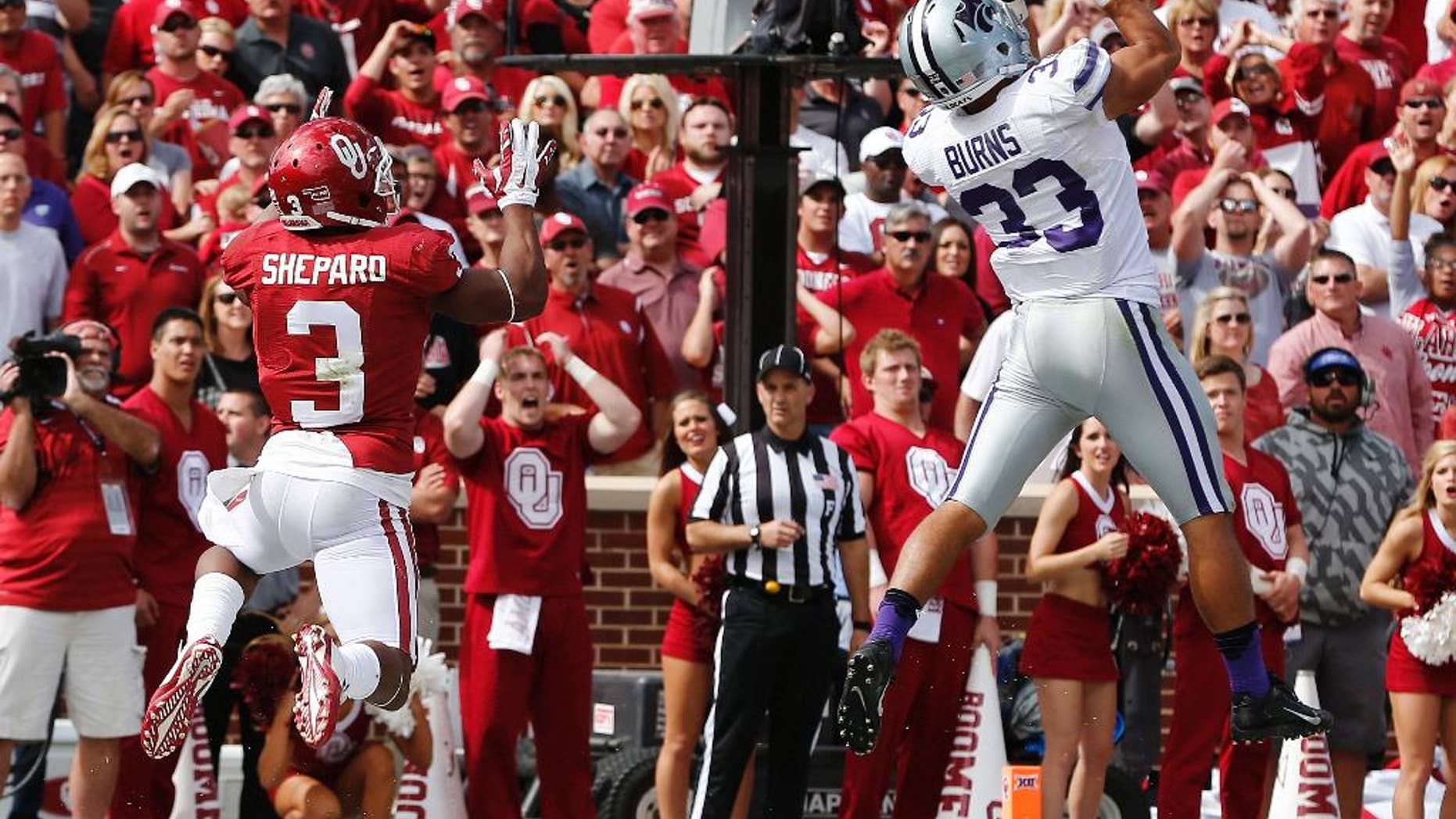 Kansas State defensive back Morgan Burns (33) intercepts a pass intended for Oklahoma wide receiver Sterling Shepard (3) in the third quarter of an NCAA college football game in Norman, Okla., Saturday, Oct. 18, 2014. Kansas State won 31-30. (AP Photo/Sue Ogrocki)