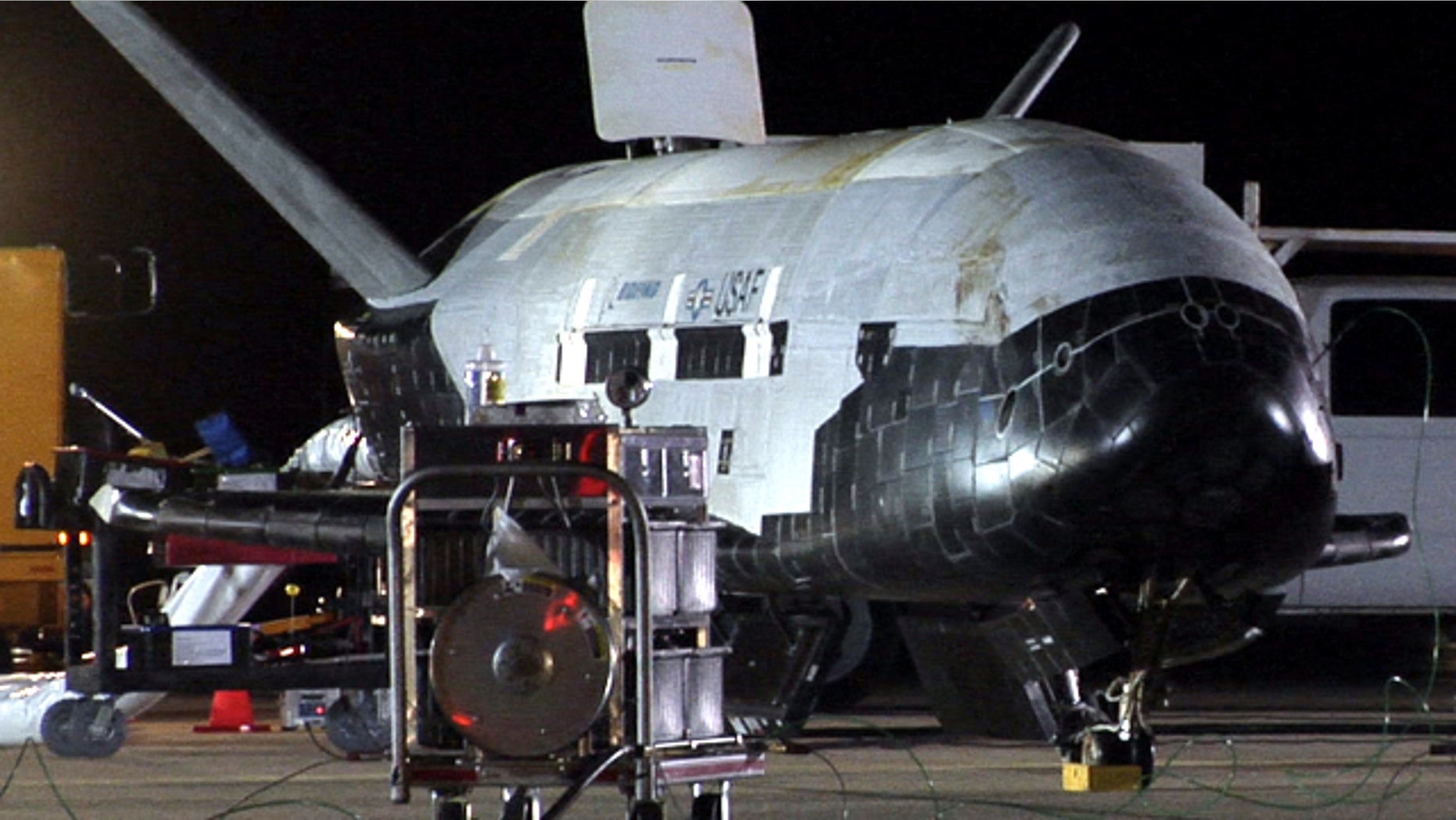 Despite its robotic nature, the X-37B space plane received a warm welcome from Air Force crews at Vandenberg. Here, the vehicle appears to be undergoing safing procedures after landing on Dec. 3 at 1:16 a.m. PST (0916 GMT). Significant weathering, or discoloration, can be seen on the spacecraft's upper thermal blanket insulation.