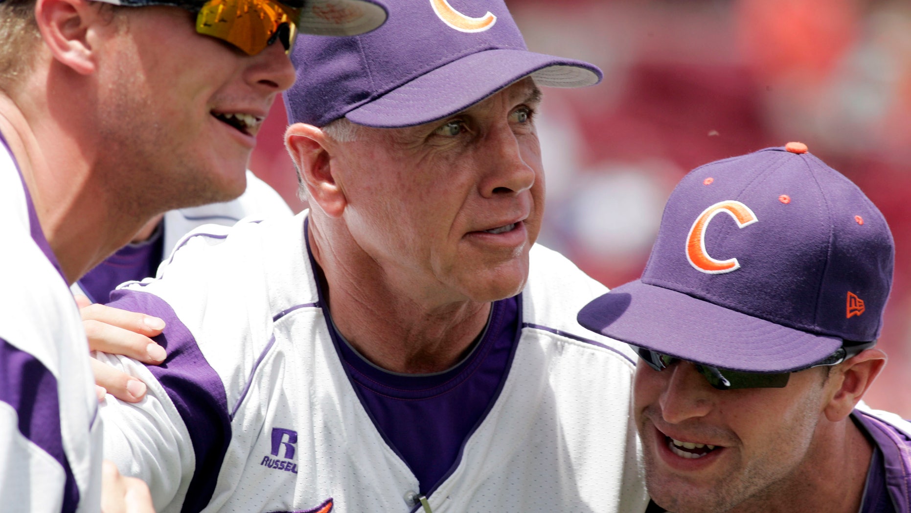 FILE - In this May 31, 2013, file photo, Clemson's coach Jack Leggett huddles witgh his players Joseph Moorefield left, and Scott Firth, right, before the start of an NCAA college baseball regional tournament game against Liberty in Columbia, S.C. Leggett will have the Tigers shooting for Omaha once more when the team opens training camp Saturday. (AP Photo/Mary Ann Chastain, File)