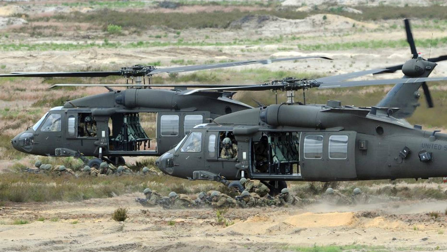 FILE -- In this June 18, 2015 file photo U.S. Army Black Hawk helicopters support soldiers during the NATO Noble Jump exercise on a training range near Swietoszow Zagan, Poland. Polish leaders say the country is buying Polish-made Black Hawk helicopters as it modernizes the army. The announcement comes days after Poland scrapped plans to buy 50 French-made military helicopters from Airbus Helicopters for 3.14 billion euros (US dollar 3.5 billion). (AP Photo/Alik Keplicz, file)