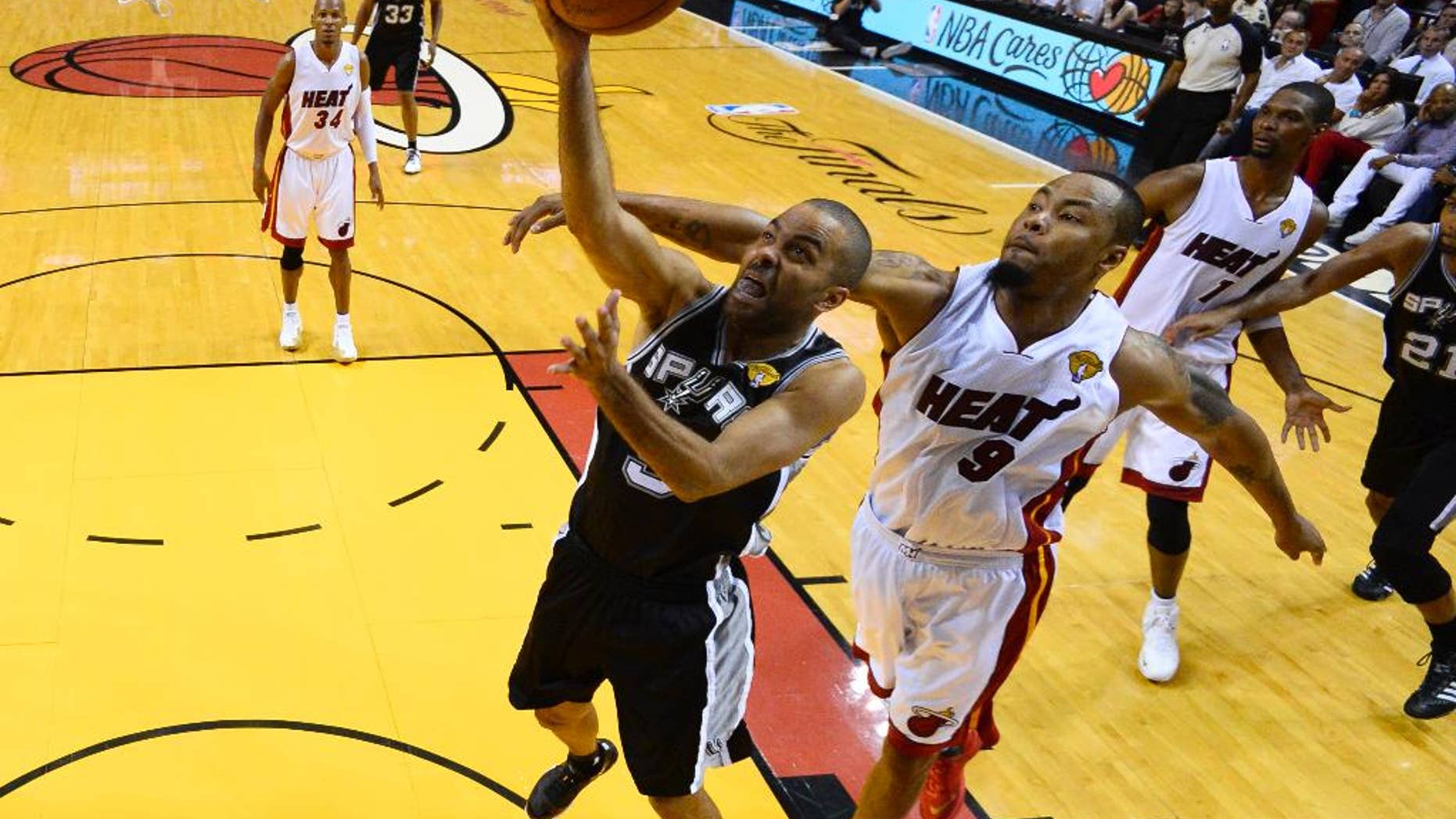 San Antonio Spurs guard Tony Parker (9) goes to the basket as Miami Heat forward Rashard Lewis (9) defends in the first half in Game 4 of the NBA basketball finals in Miami, Thursday, June 12, 2014. The Spurs won 107-86. (AP Photo/, Larry W. Smith, Pool)